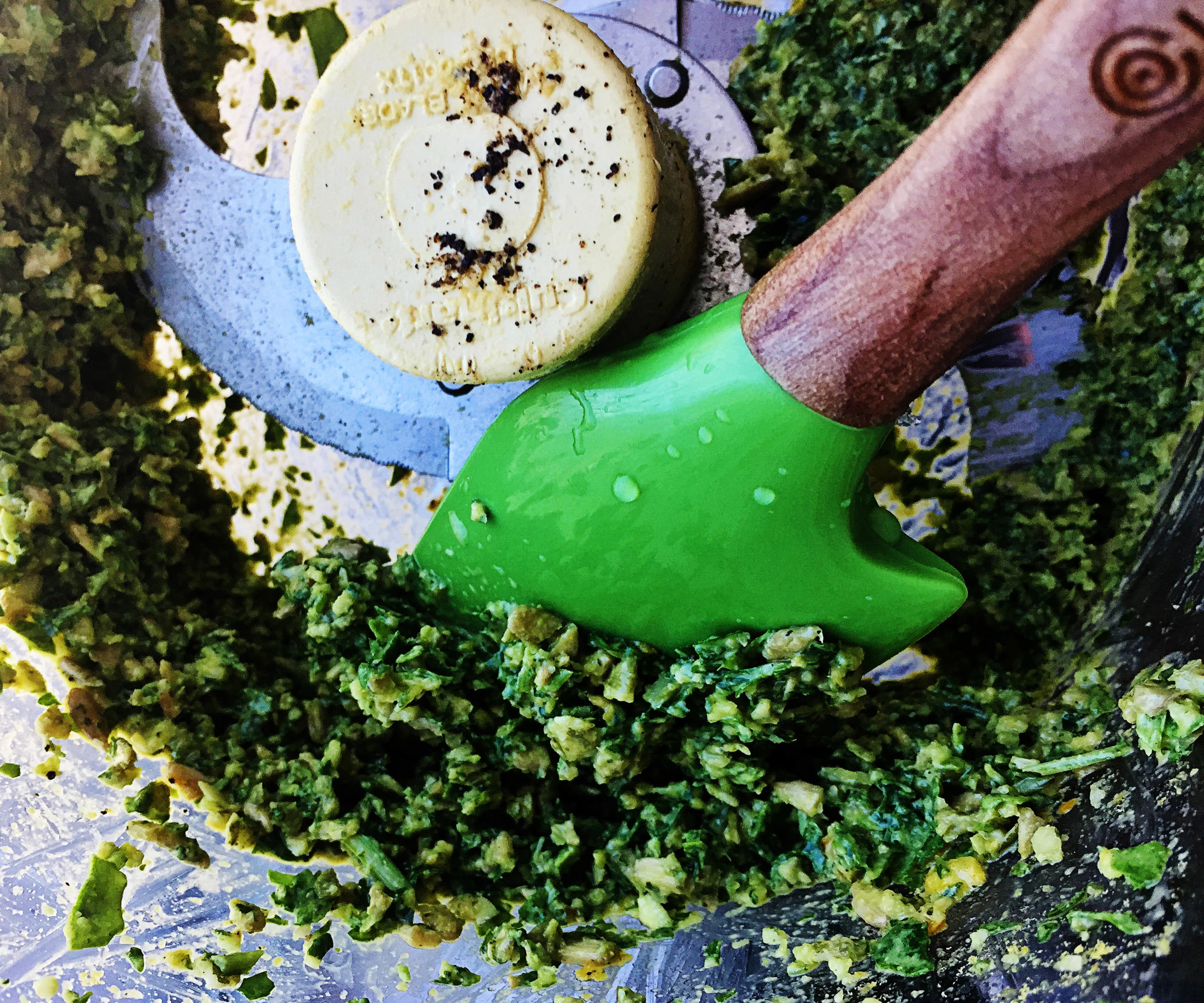 3. Turn on your food processor and begin to pour in the 2 tbl of olive oil slowly. After your are done pouring it in, take off the lip, scrape down the sides, and run for another few seconds. I like it a little chunky versus creamy.
