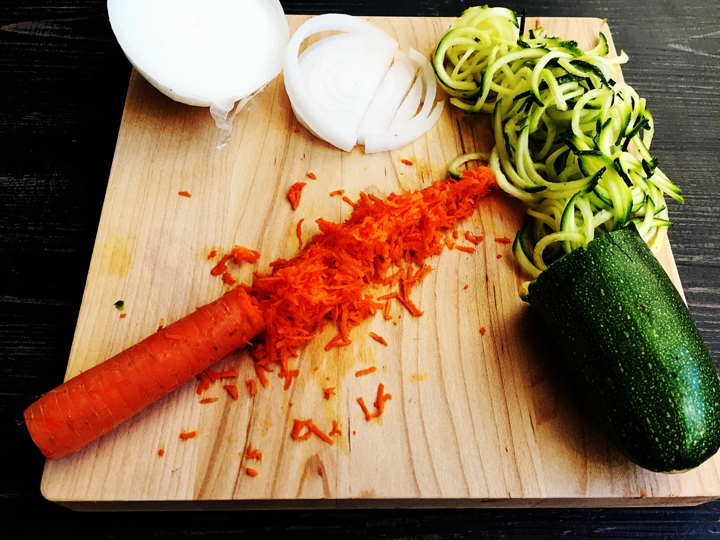 3. Next we will cook the "pork." Now, it is important to get the following ingredients done in this way to provide the right texture. Spiralize your zuke, grate your carrots, and dice your onions small. Add oil to castiron pan, and heat for couple minutes over medium. Add onion and cook for 4-5 minutes. 
