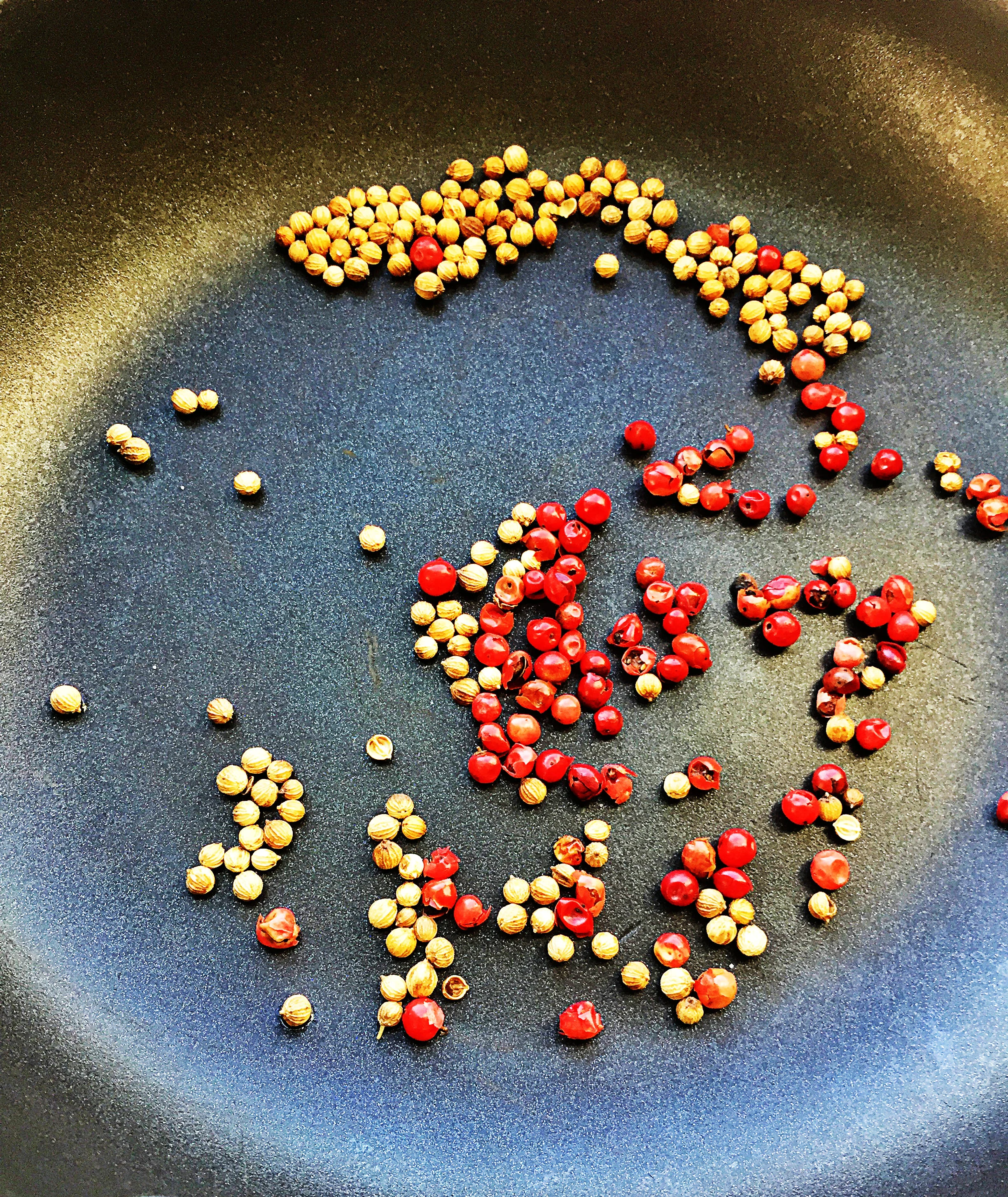 2. First step in making these thai tacos, is to place a small frying pan with pink peppercorns or coriander seeds in it over medium-high heat. Toast for roughly 6-8 minutes until some browning and fragrance occurs. 