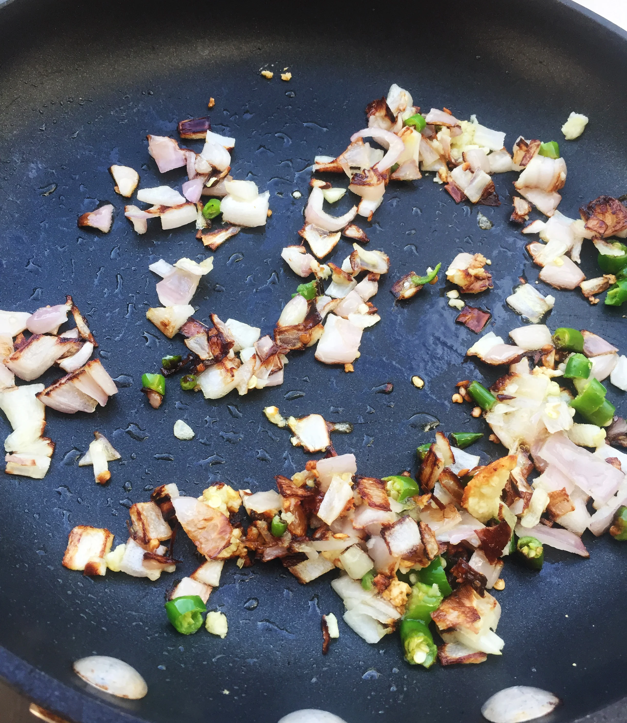 5. Add oil to medium frying pan and put over medium heat. After 60 seconds add shallots, chiles, and garlic. Saute for five minutes. Set aside. Keep pan on the burner.Add a bit more oil.