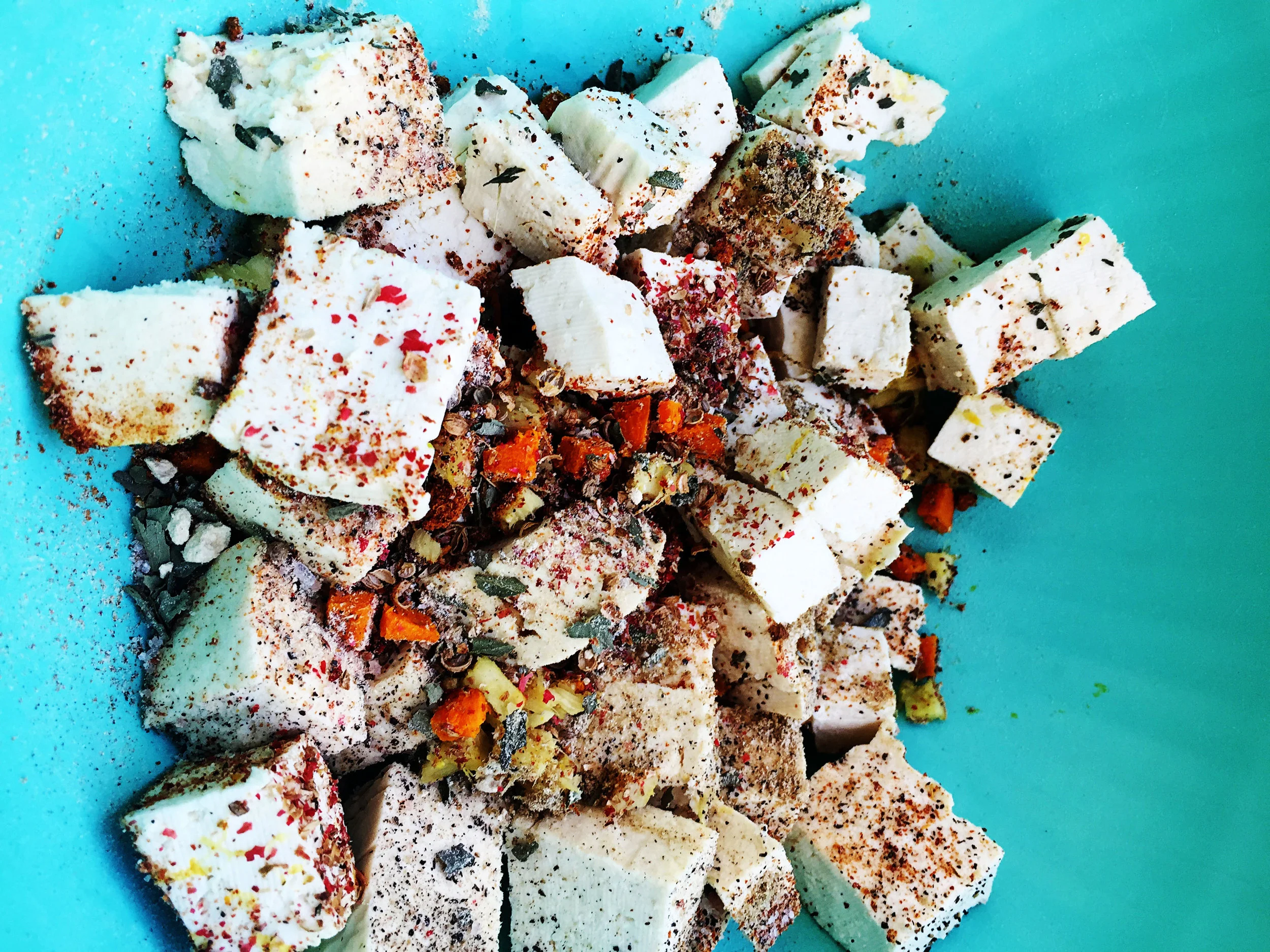 6. Put tofu, sauteed ingredients, and the rest of all spices into a mixing bowl and stir well. Place back into the pan, turn down heat a bit and saute for 6-8 minutes until tofu starts to brown and crisp on he sides.
