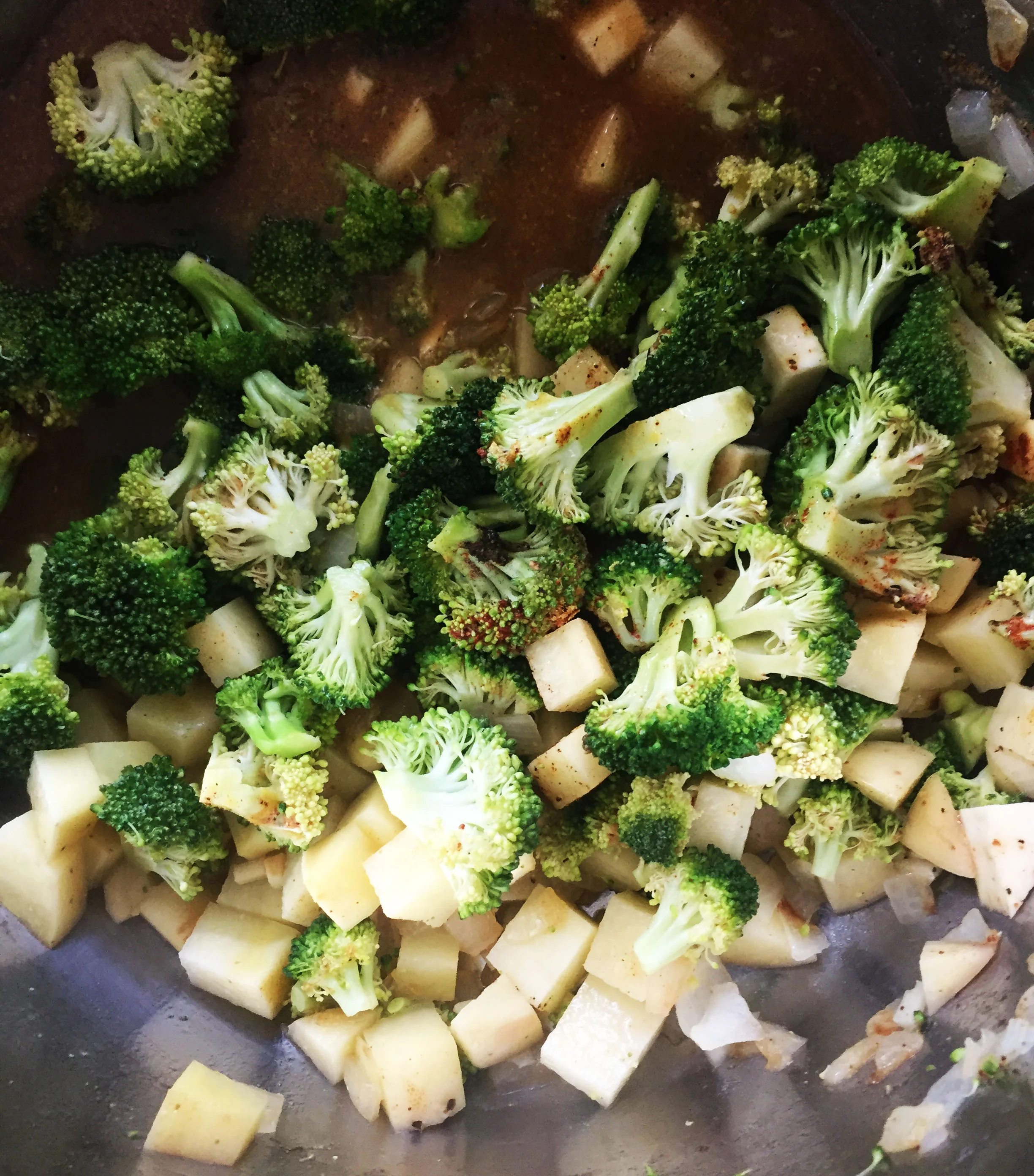 4. Next, add the broccoli, parsnips, and potato to the pot as well. Saute for a minute or two. Then add broth and all spices. Bring to a high simmer, cover, keep at medium for 15 minutes. 