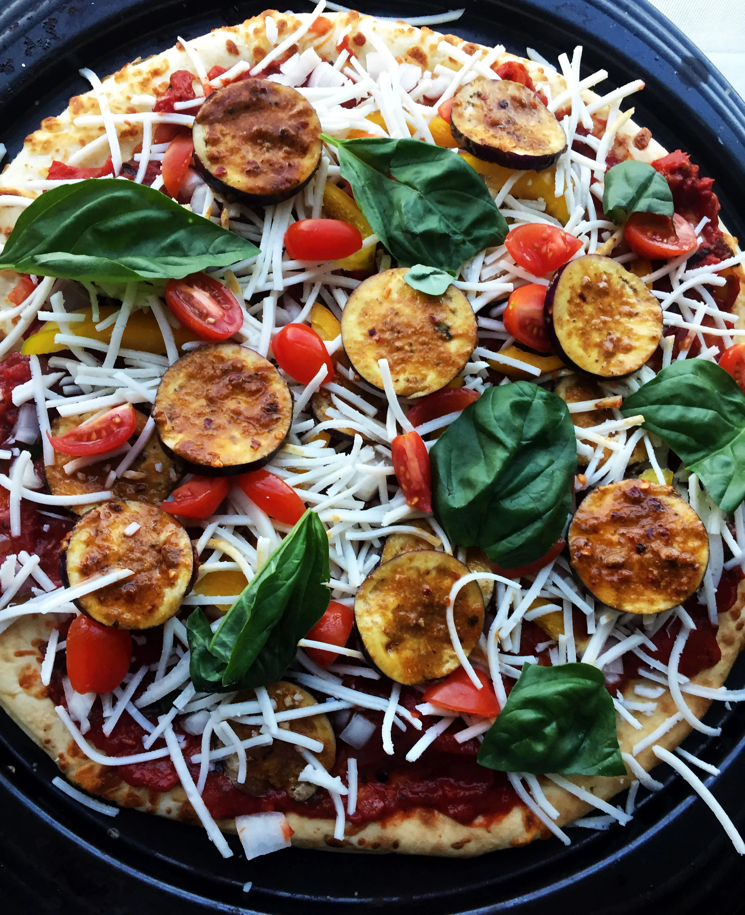 8. Add the cheese, pepperoni slices, a few grape tomatoes, and basil pieces. 