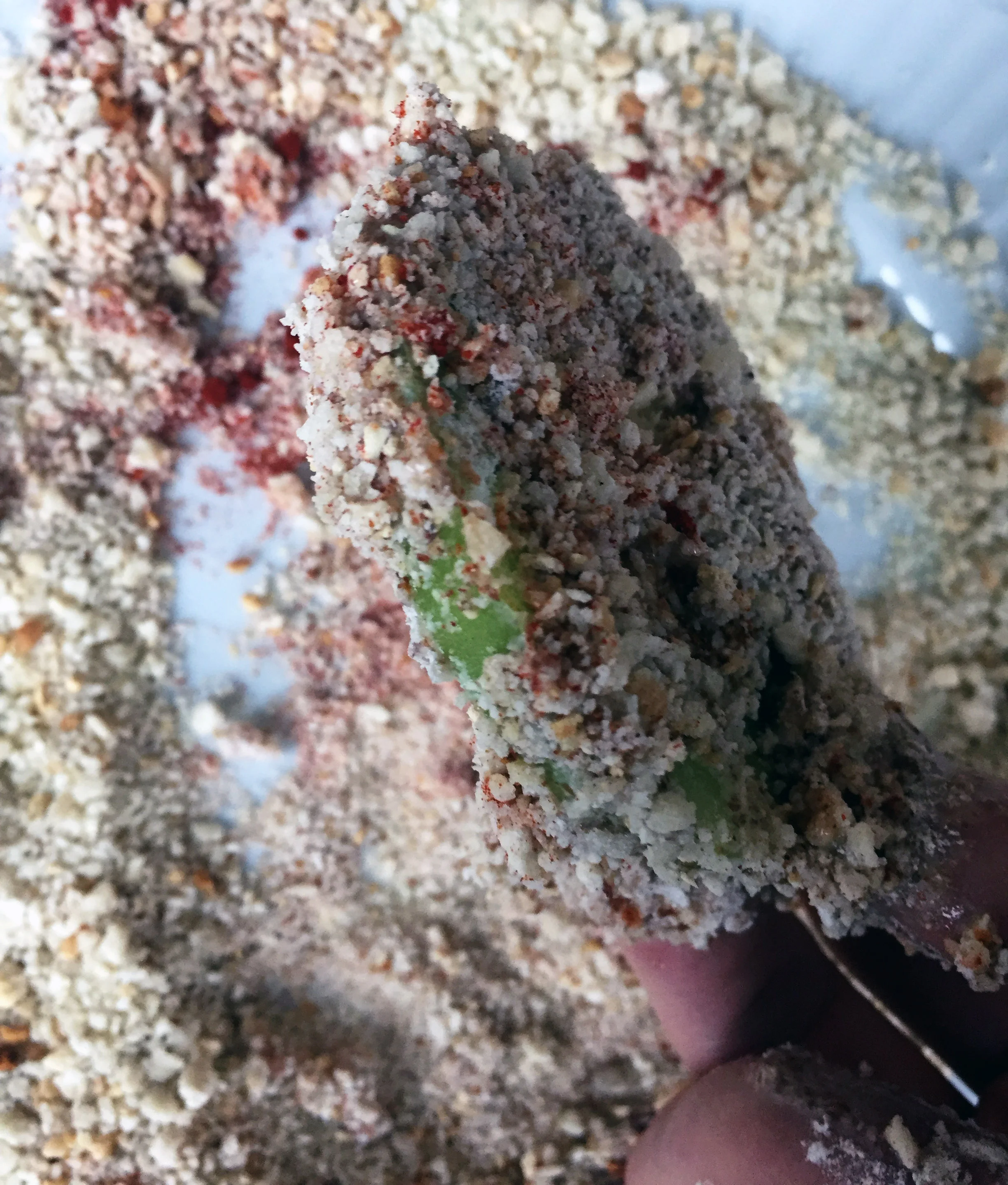 7. Coat the tomato in the breadcrumb mixture.