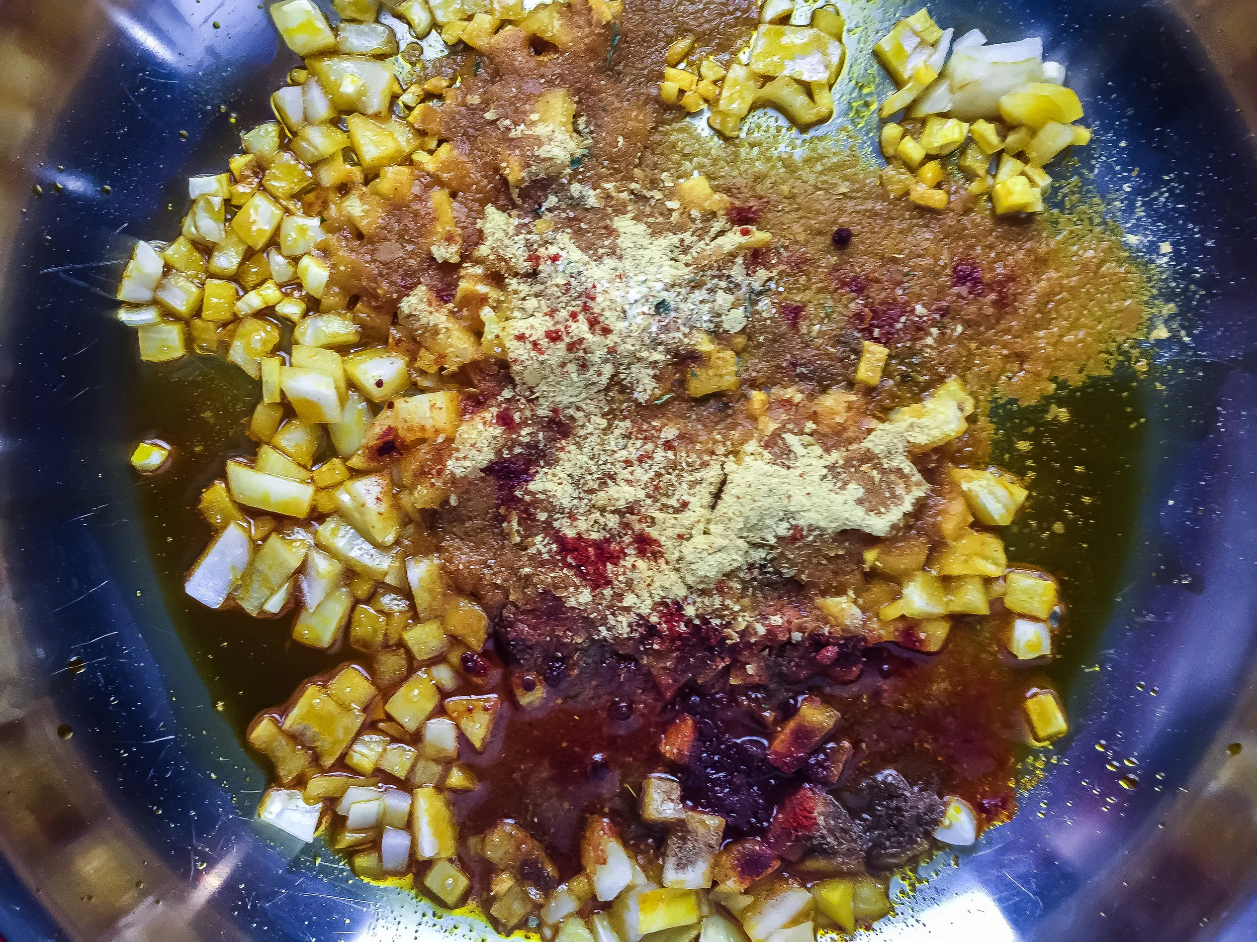 1. Start with the queso. Place palm oil in medium/large frying pan. Warm for 60 seconds over medium heat. Cook up onions and garlic for 4-5 minutes. Add in spices. Mix well. Cook another two minutes.