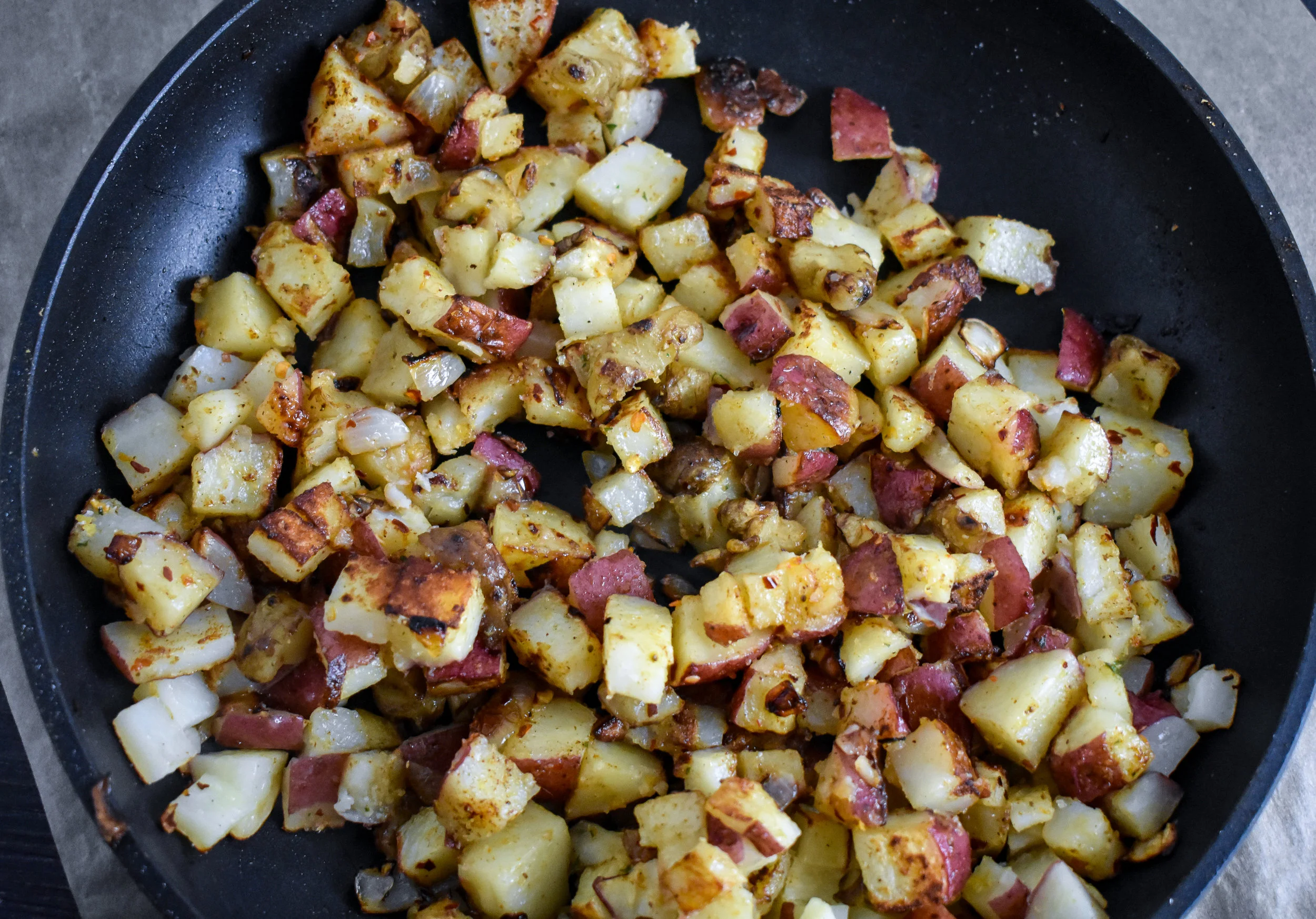 4. Once potatoes and sunchokes are in the plan, add the other tbl of oil and spices. Turn the heat to medium-high, cook for 90 seconds then flip, cook another 90 seconds. Continue this until you get a sear you like. Once that is done, add in the cheese and set aside.