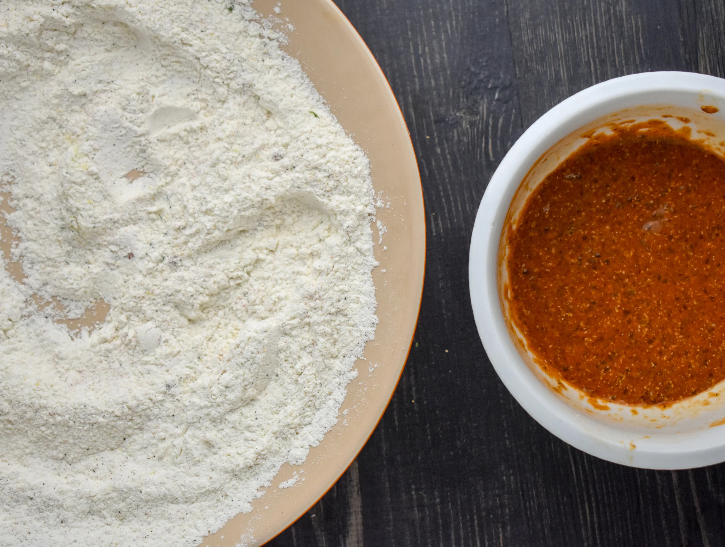3. While the chicken boils, set up your battering station. Mix everything under the flour station into a large shallow bowl. Mix everything under the liquid station into another smaller bowl.