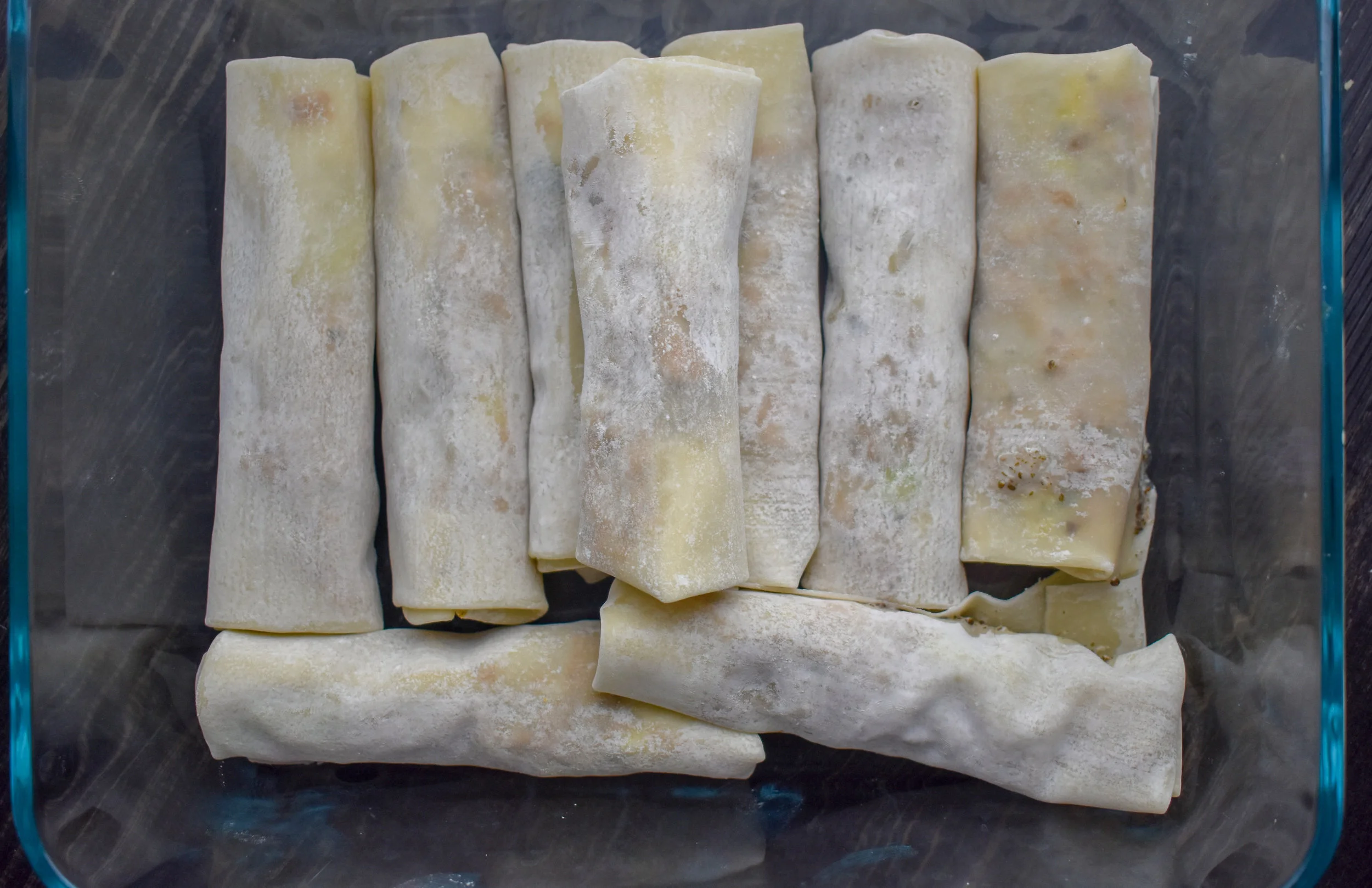 11. Stack your spring rolls into a baking dish...try to have just one layer. If you have more than this, use another baking dish. Before placing into the oven, coat the wrappers with olive oil lightly using the pastry brush. Cook for 15 minutes, flip them, cook another 10 minutes. Set aside to cool.