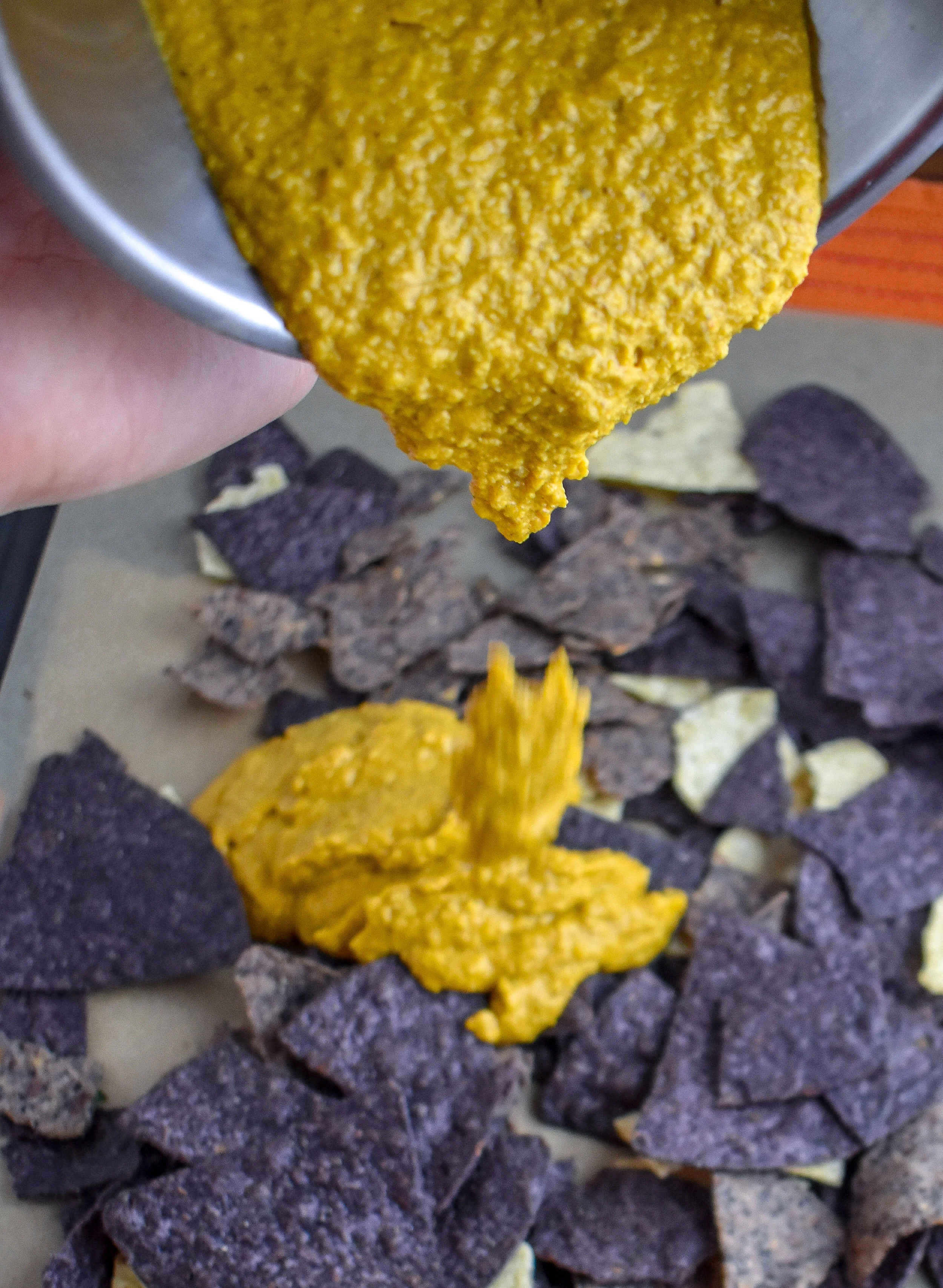 5. Once the queso is done, spread chips on a parchment-lined baking sheet and pour queso over top.