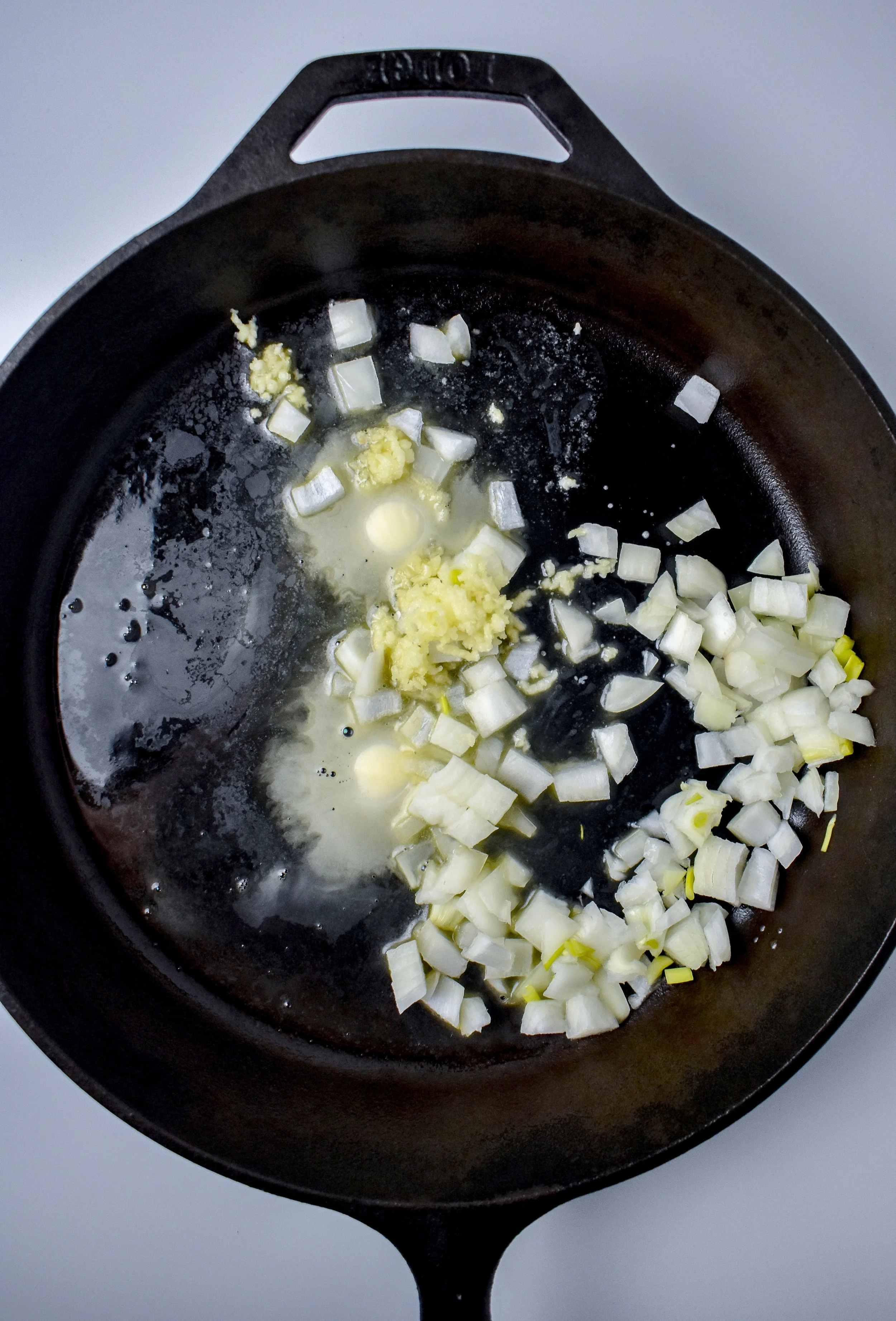 2. While the potatoes cook, add butter to castiron pan over medium heat. Add onions + garlic for veggies to the pan and cook for 3 minutes over medium heat.