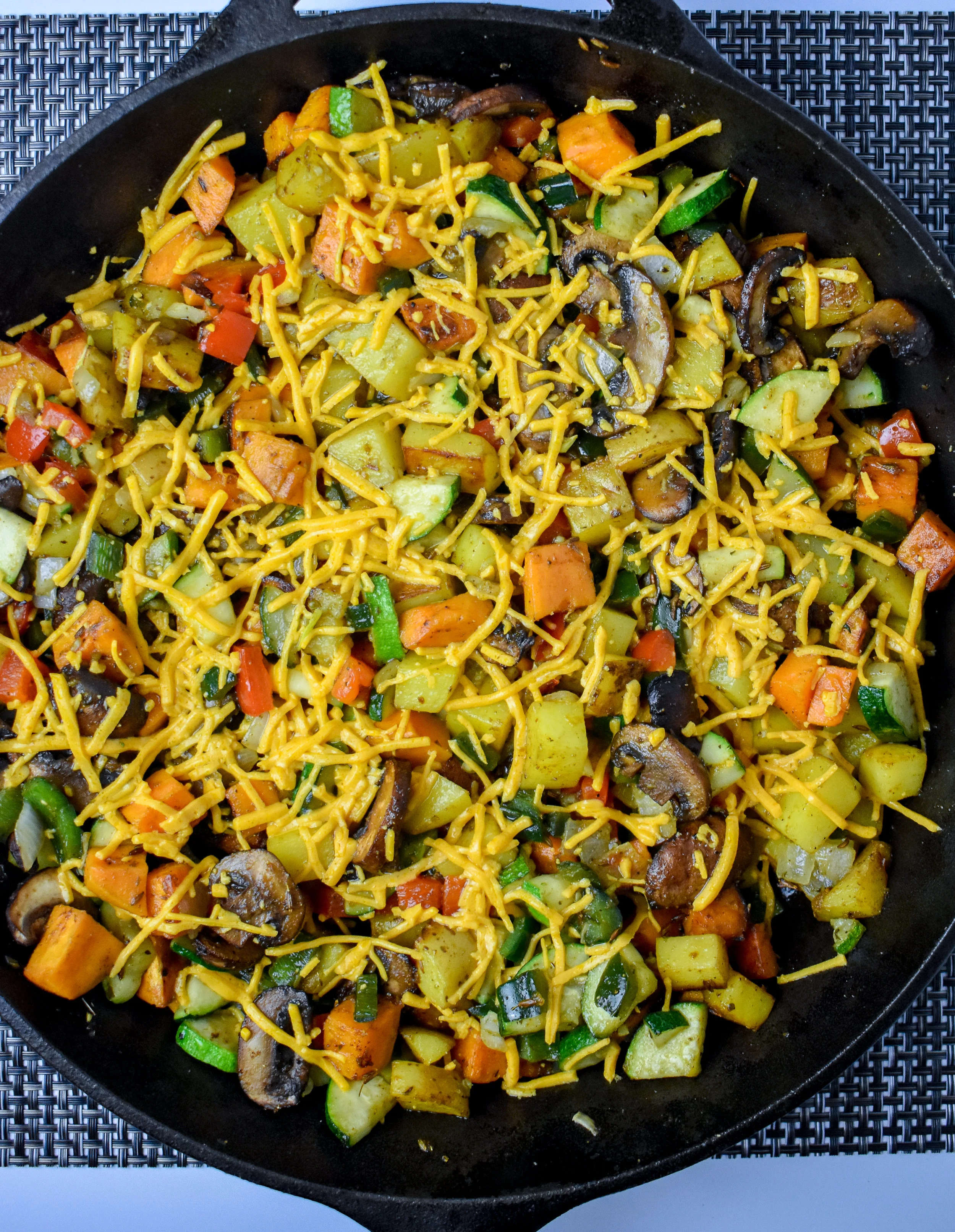 7. Next, once the potatoes are done. Turn off the heat. Add in the veggies + mushrooms. Mix well. Sprinkle on cheese + green onions. Let sit.