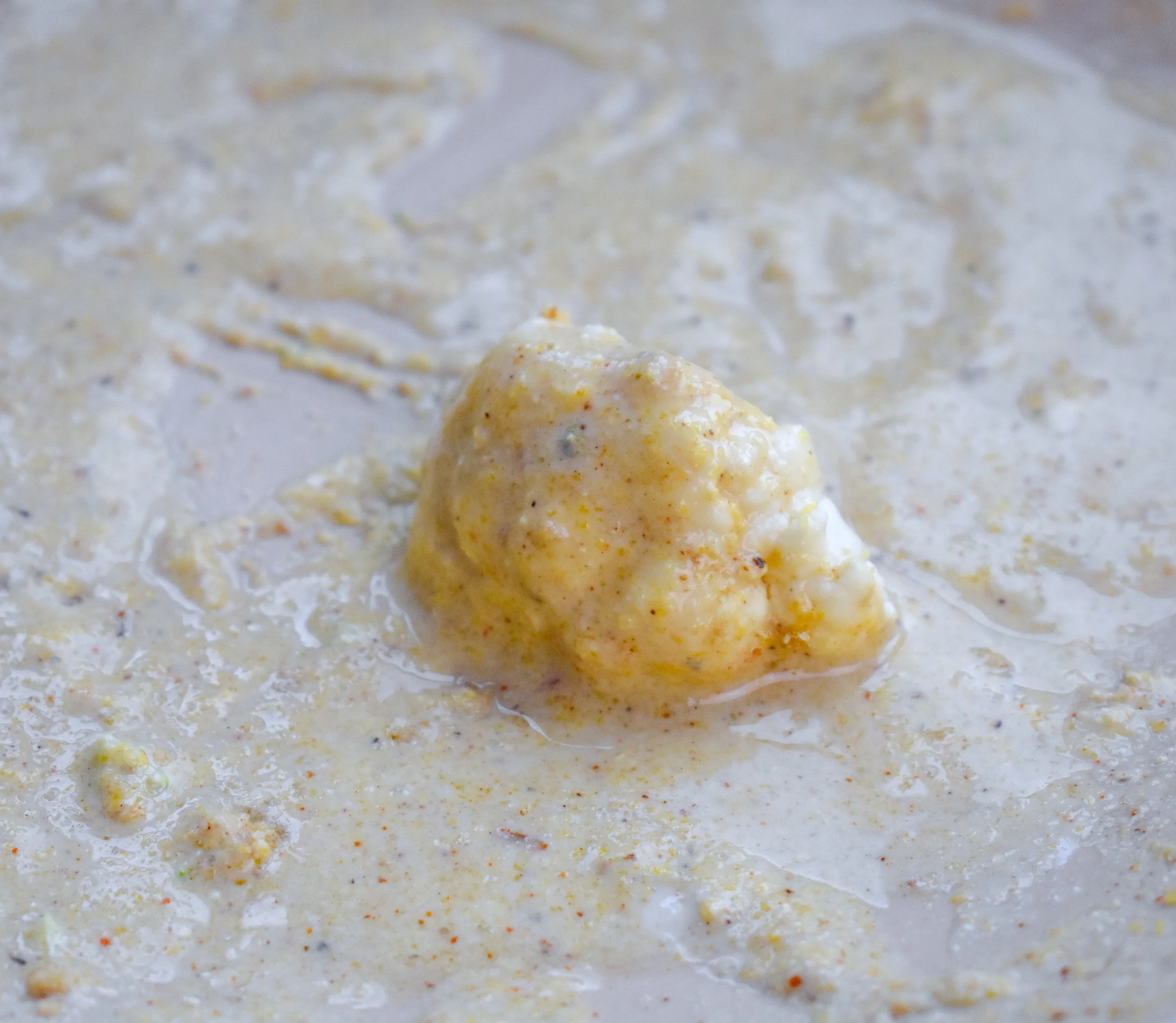 4. Start by dipping the veggies into the cornmeal bath. Dunk the piece into the bath and pull out and let it drip off.