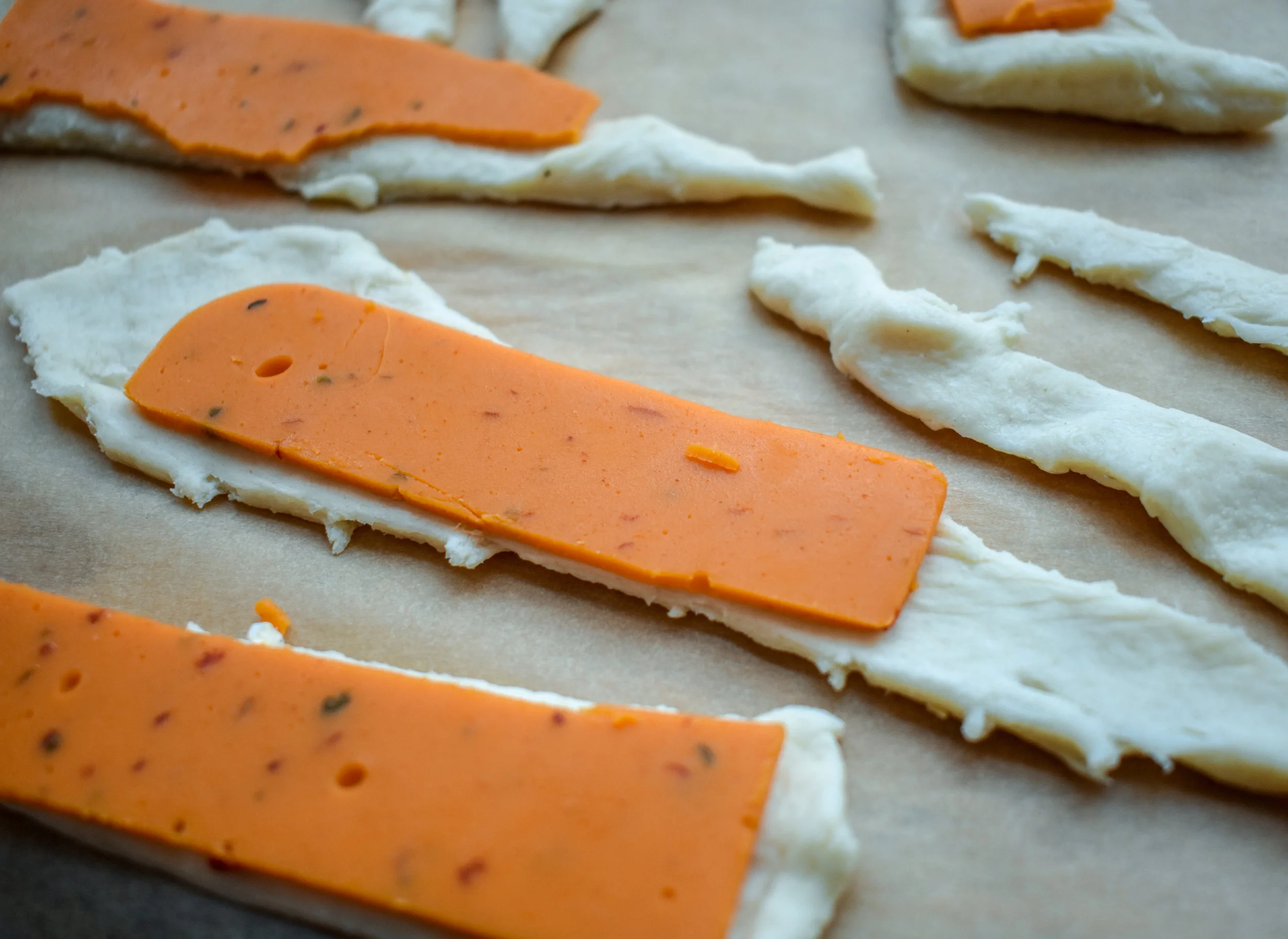 7. This step is optional. To 1/2 of the rolls, I added pepperjack cheese. I just laid it on top of the crescent roll half before rolling up the dogs.