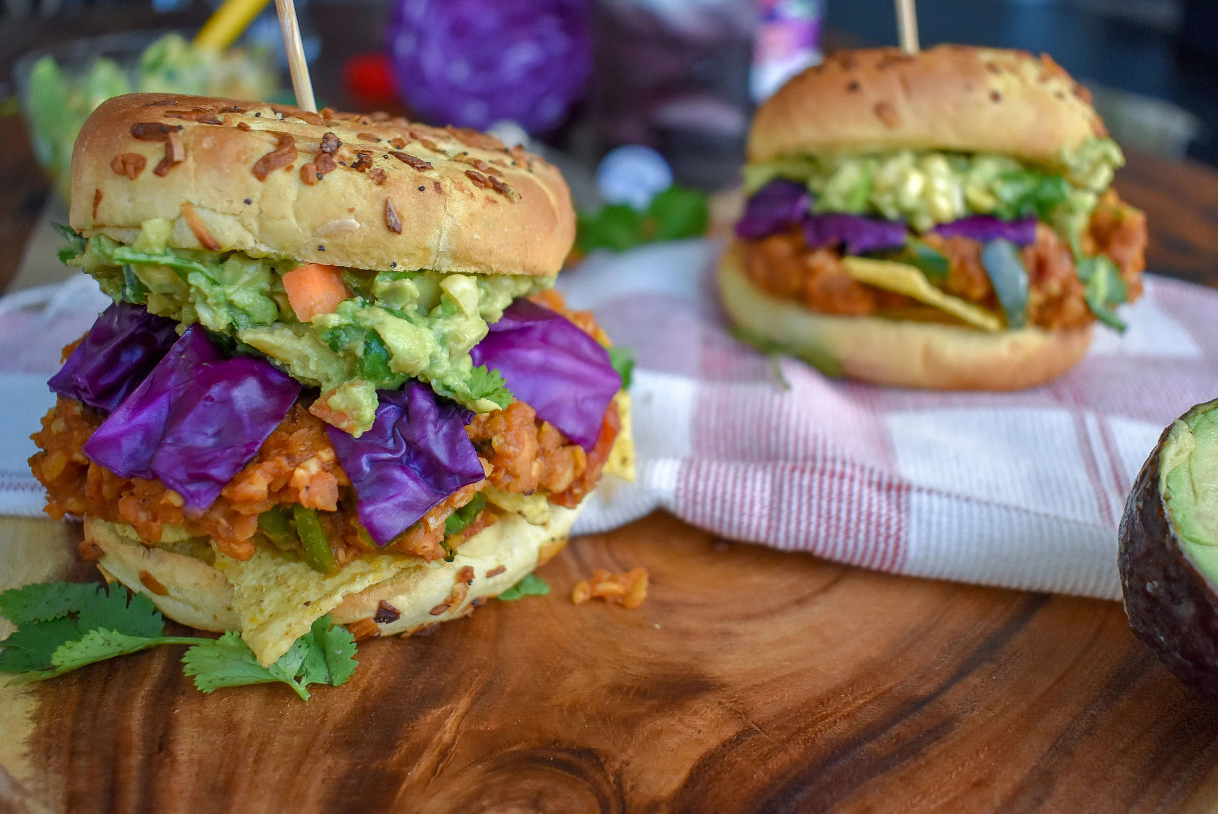 7. To finish, I toast up my onion rolls, add the layer of tort chips, a healthy layer of the sloppy joe, and then cabbage and guac. Cheers, enjoy!