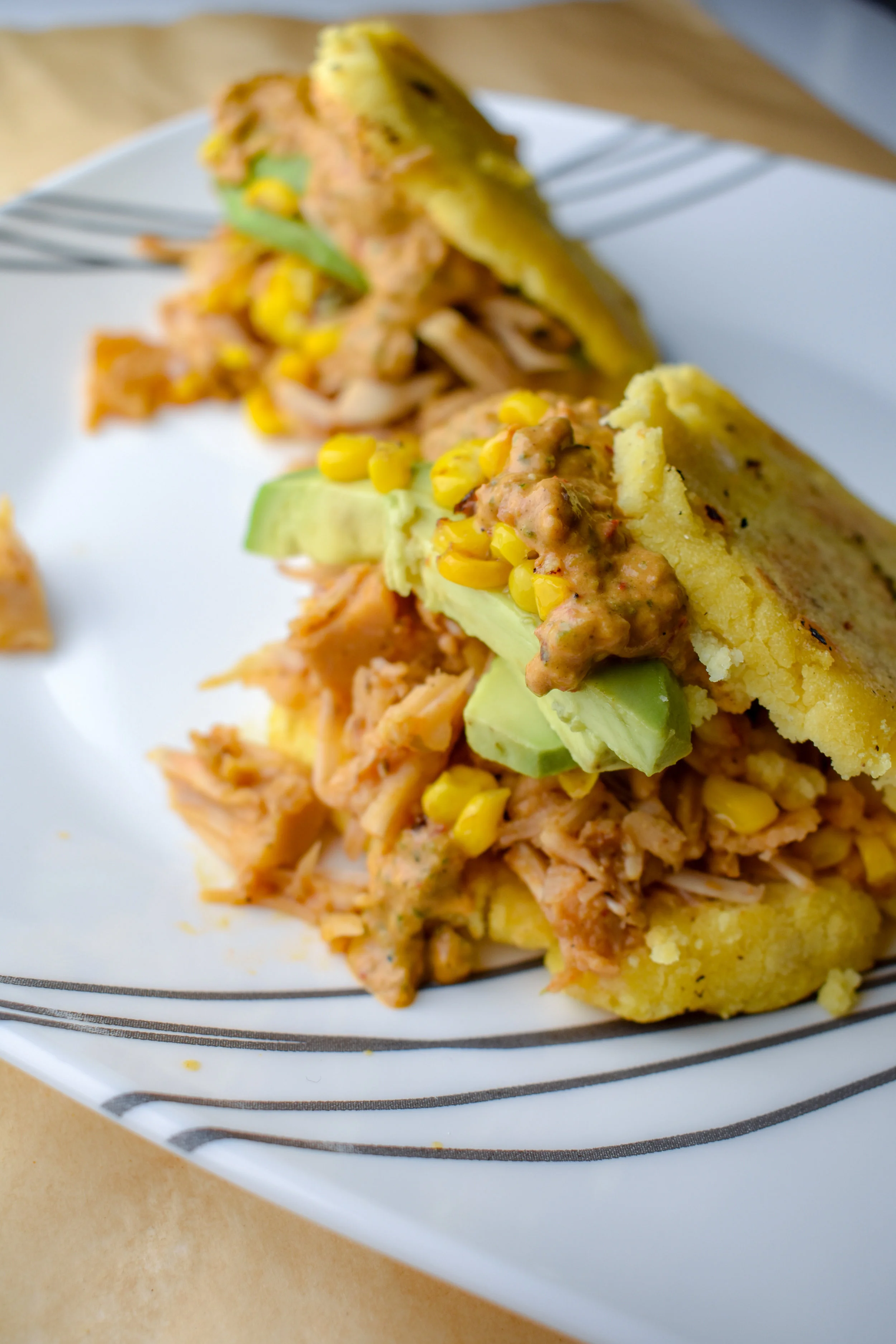 10. At this point, check on your carnitas. They should be done. To form the arepa, slice like a pita pocket and layer in the ingredients with carnitas on the bottom, 1/4 the lime corn, 1/2 avocado sliced, and 1/4 the poblano sauce. It will be pretty packed and gets messy but that's the beauty of it! Enjoy!