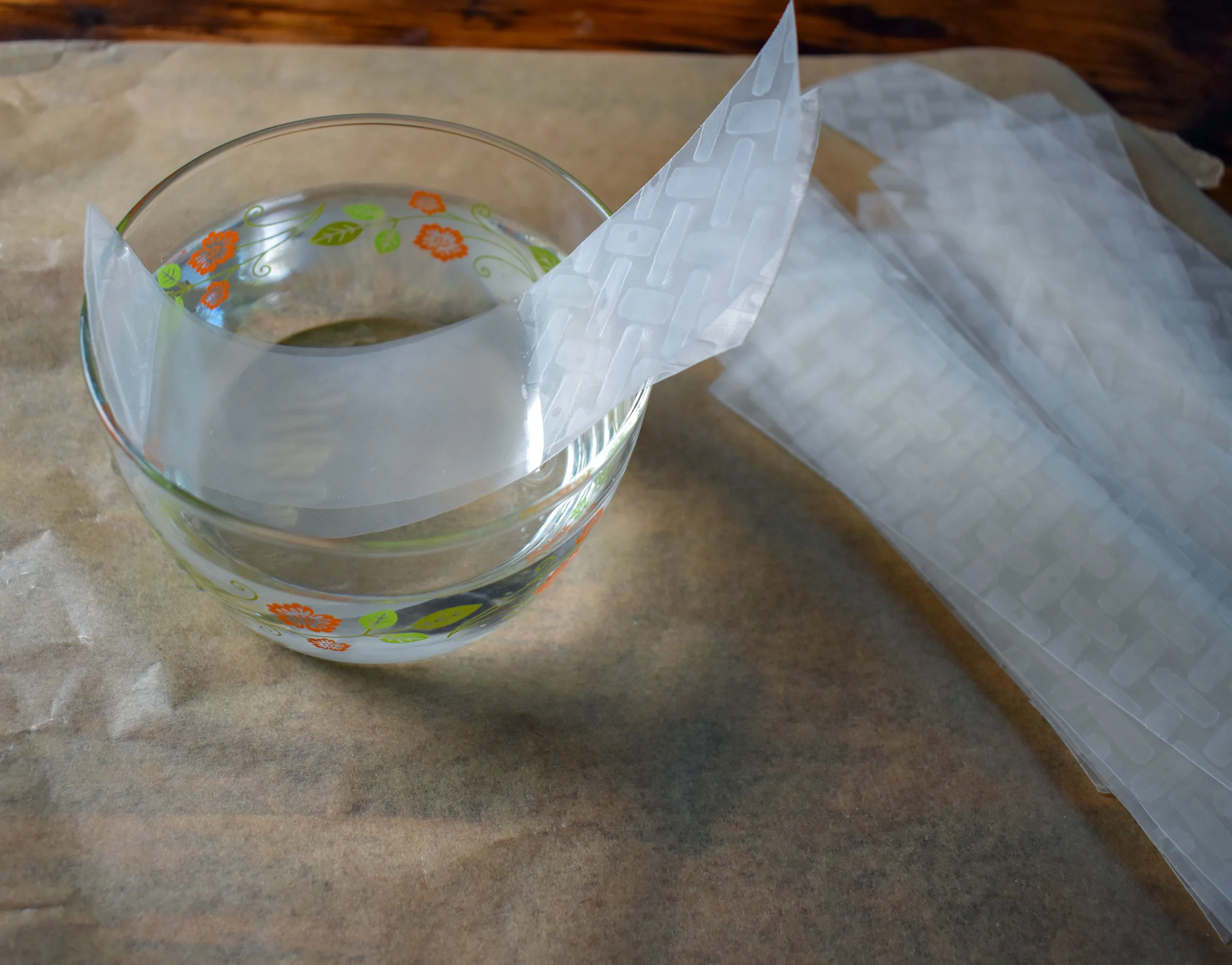 4. Holding the pair together, dunk it in a bowl of water and as you bring out of the water run your fingers down the sheets to remove excess water. Place onto parchment paper.