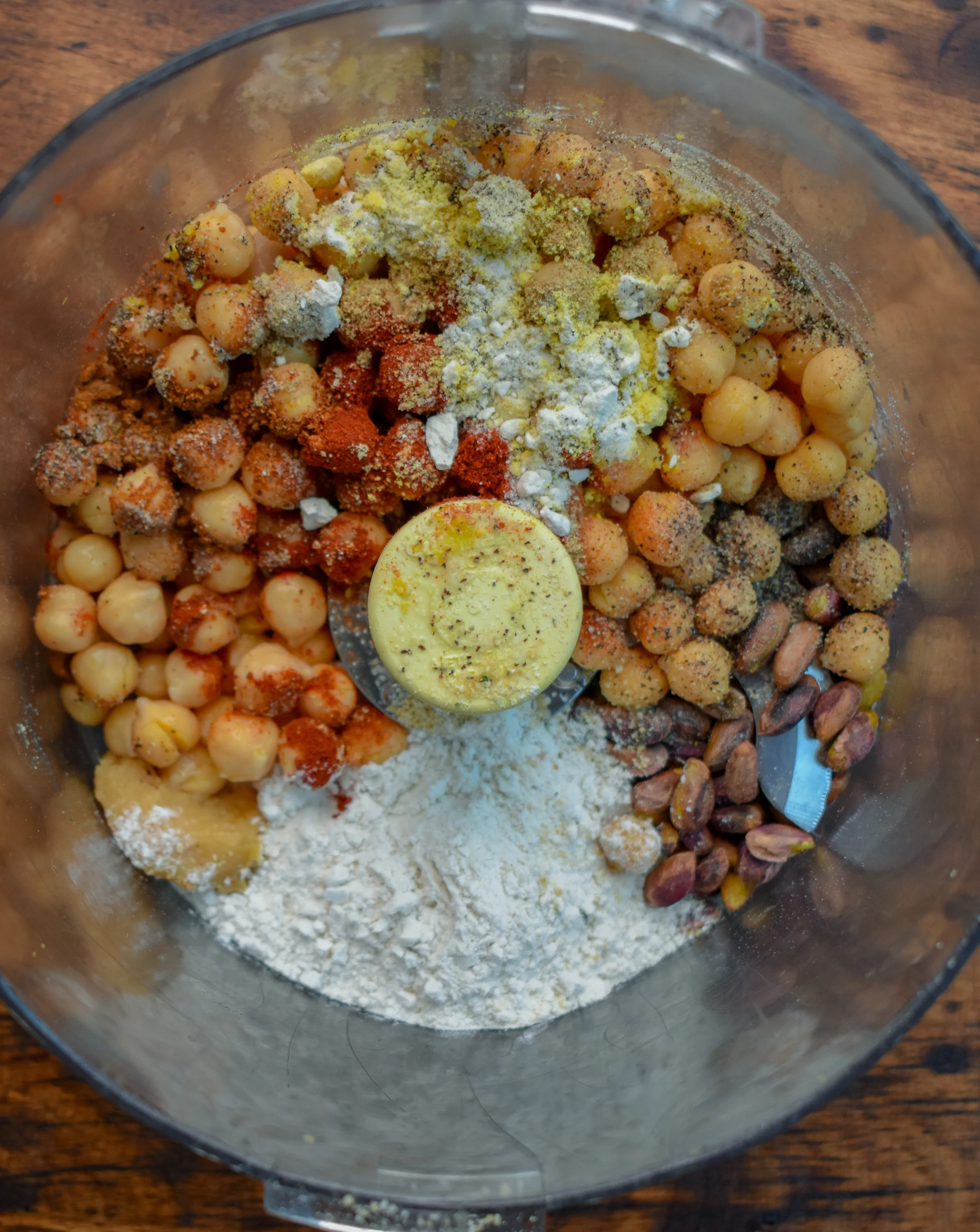 3. To a food processor/high-speed blender add pistachios, chickpeas, chili powder, paprika, oregano, coriander, pepper, and salt. Pulse 10-15 times until the chickpeas are broken down into very small pieces.