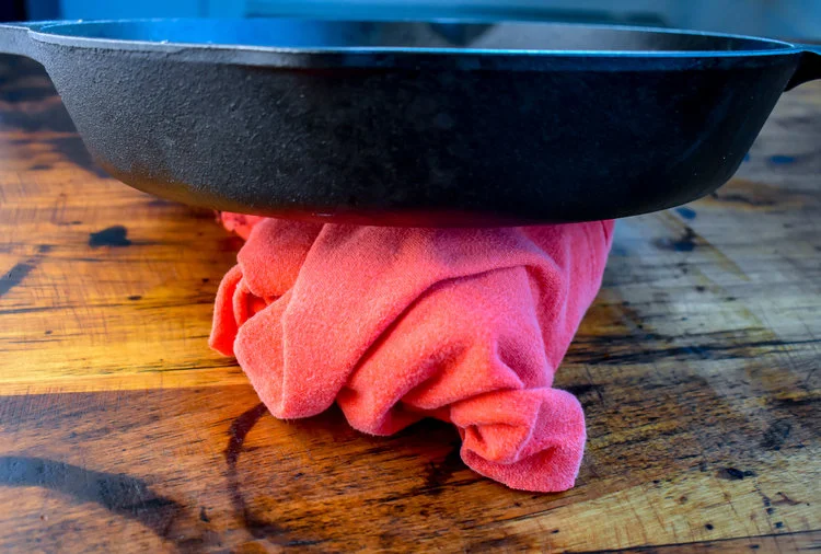 1. Start by wrapping the tofu in a tea towel or thin, clean dish towel. Place a castiron pan on top of it or other heavy pot/pan. This process helps draw out the water and dry the tofu. Let it sit for 15 minutes.