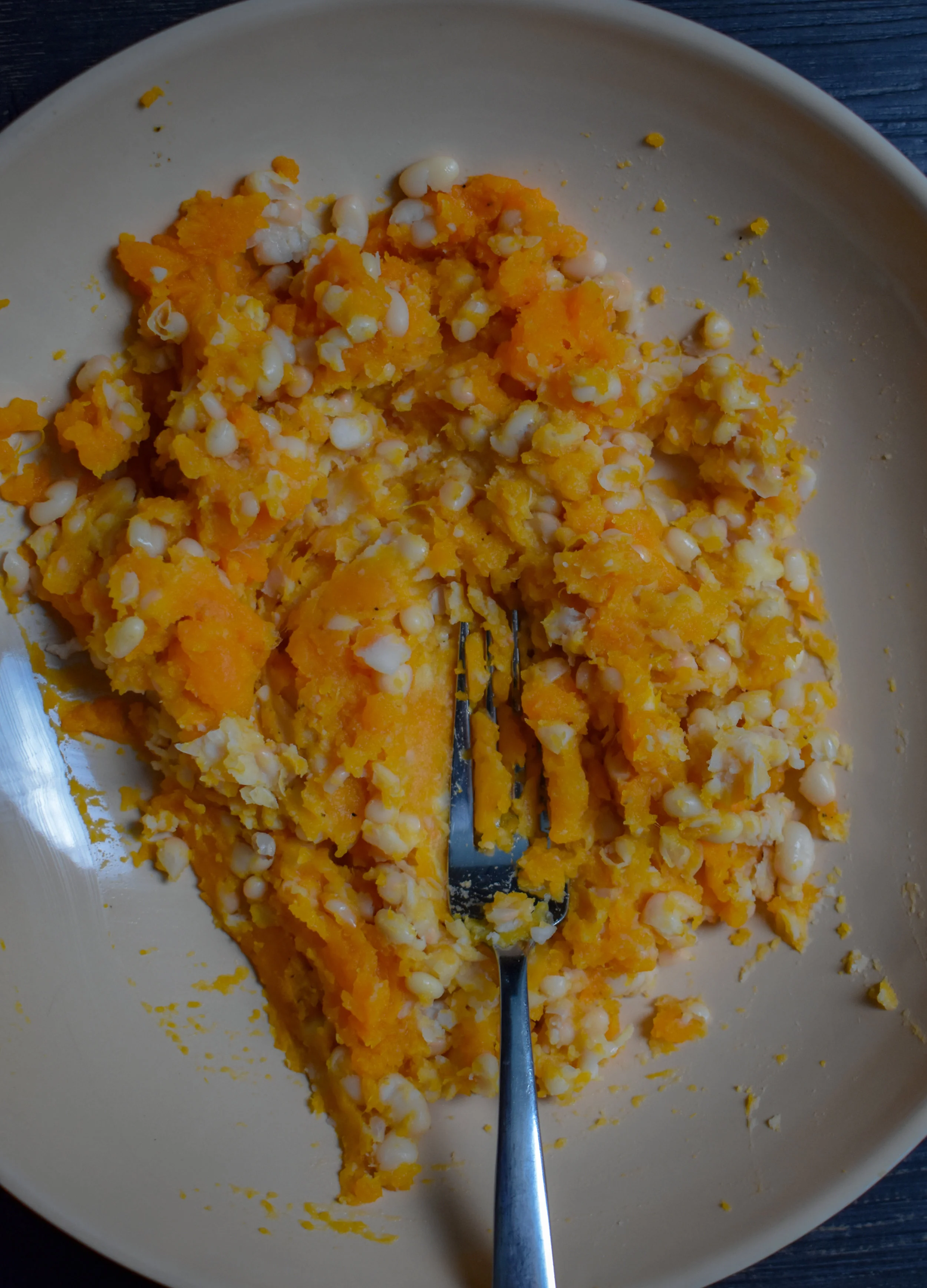 5. Once the sweet potato is cooled, scoop out the flesh. Using a fork, mix it together with the white beans until it is a firm mixture. Leave it with some chunks though.