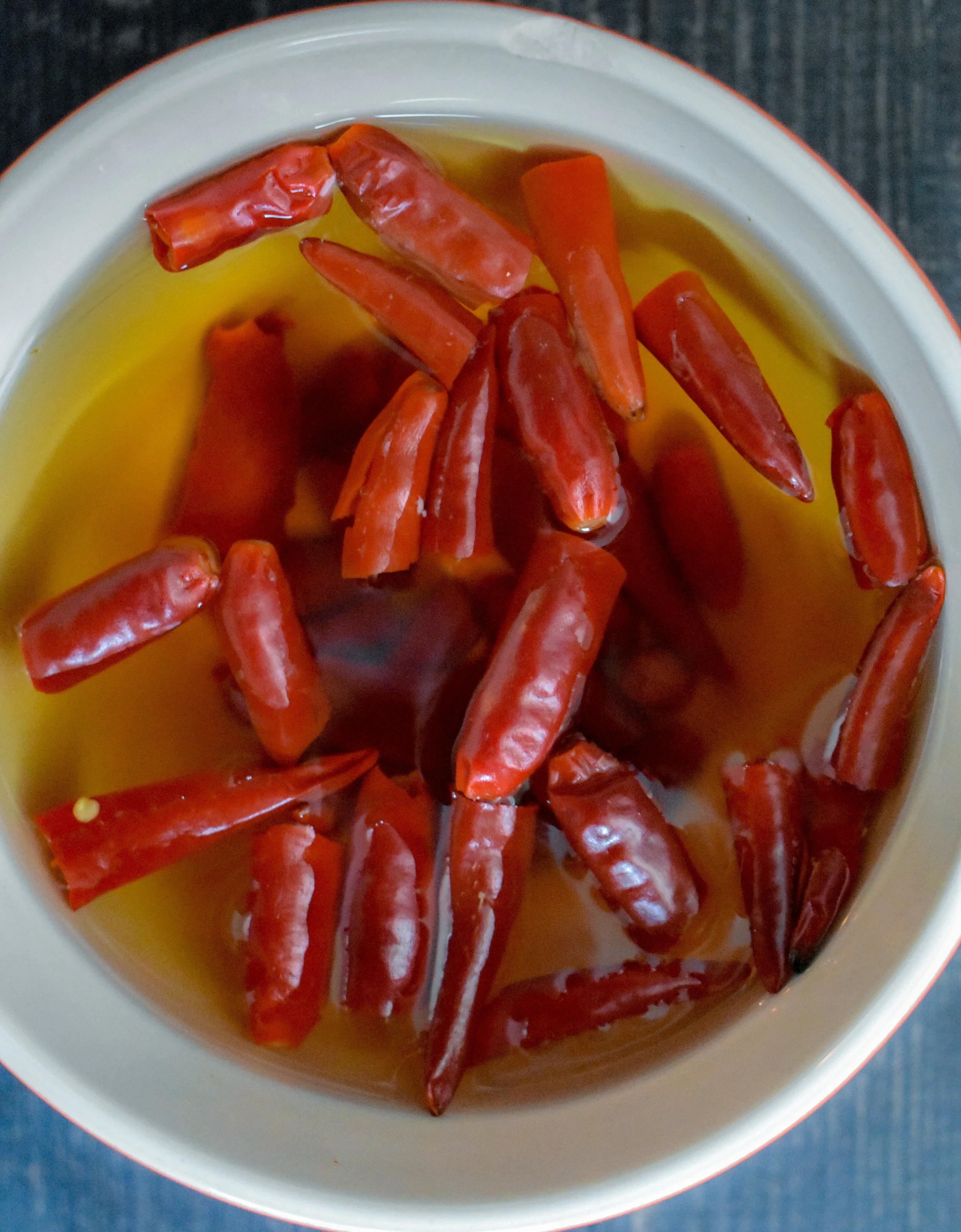 1. To start, take the halved and deseeded dried chilis and place into a medium-sized bowl. Add in water once it has been brought to a boil and soak chilis for 25-30 minutes.