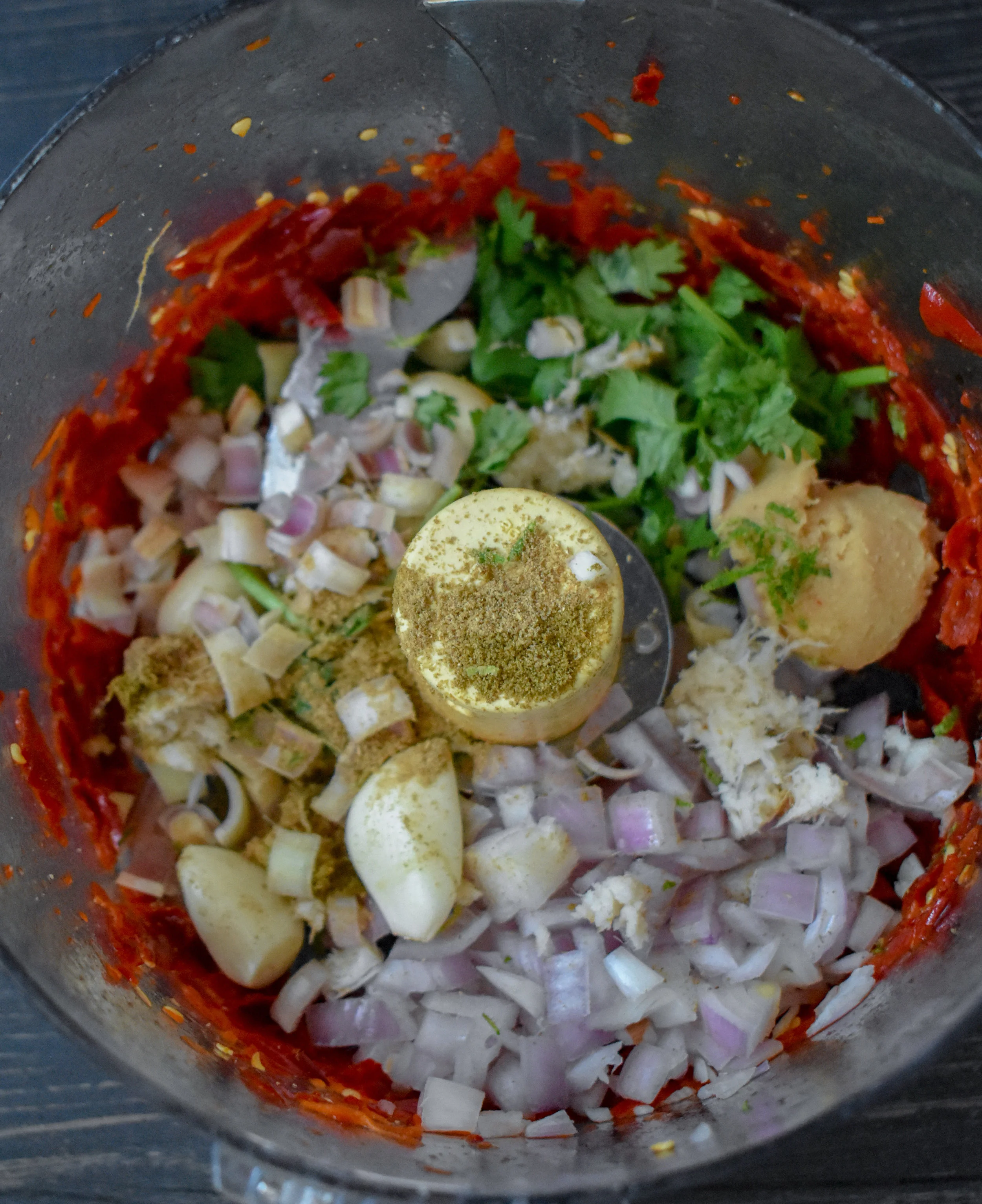 3. After pulsing the chilis, add the rest of the ingredients to the food processor. Pulse 10-15 times until well broken down and a paste starts to form.