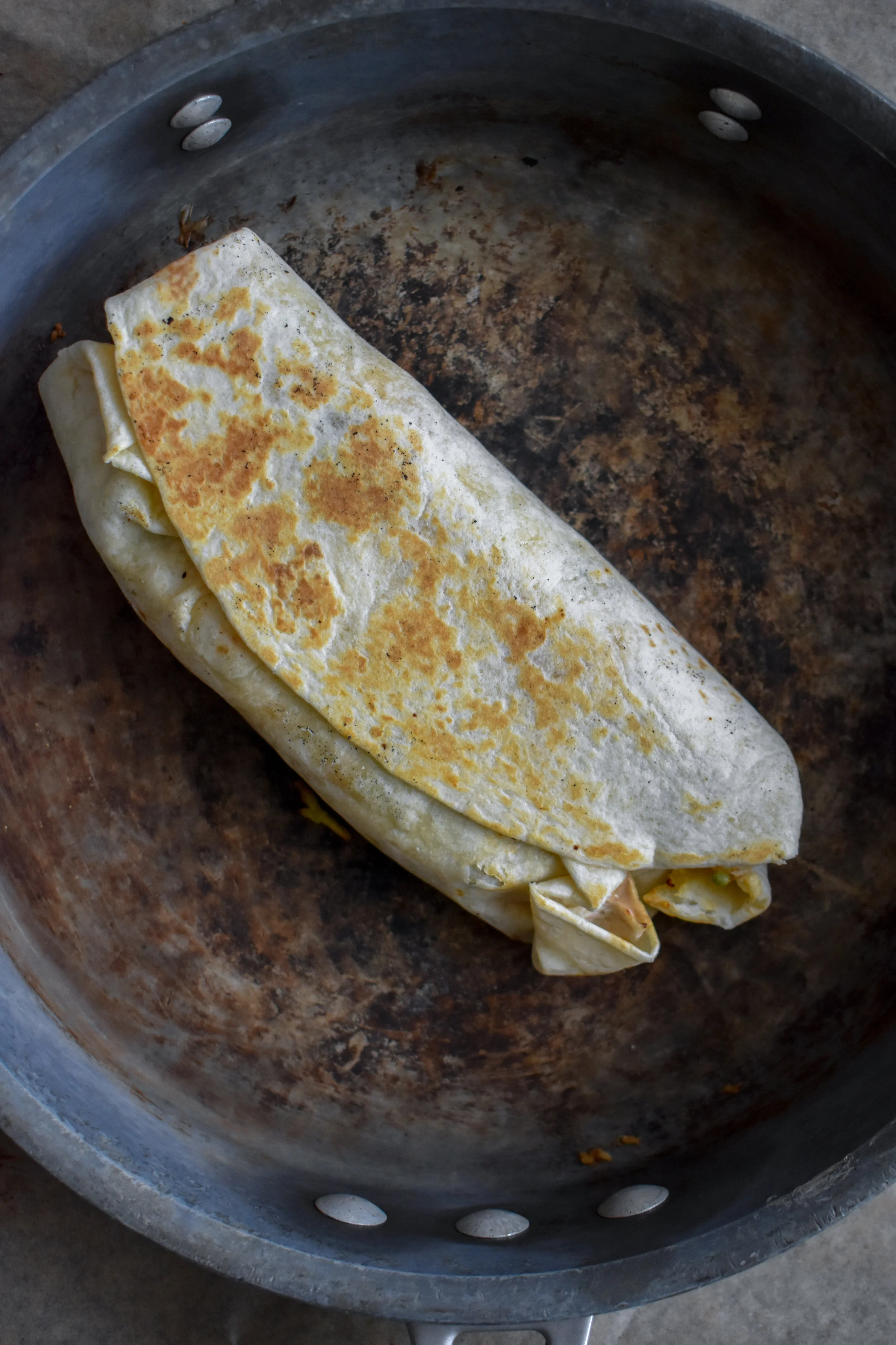 10. Once the burrito is filled, roll it tight folding in the ingredients. Place into the hot dry pan. Cook on each side for about 45-60 seconds. Use another pan to pres it if you want to get an even better sear.