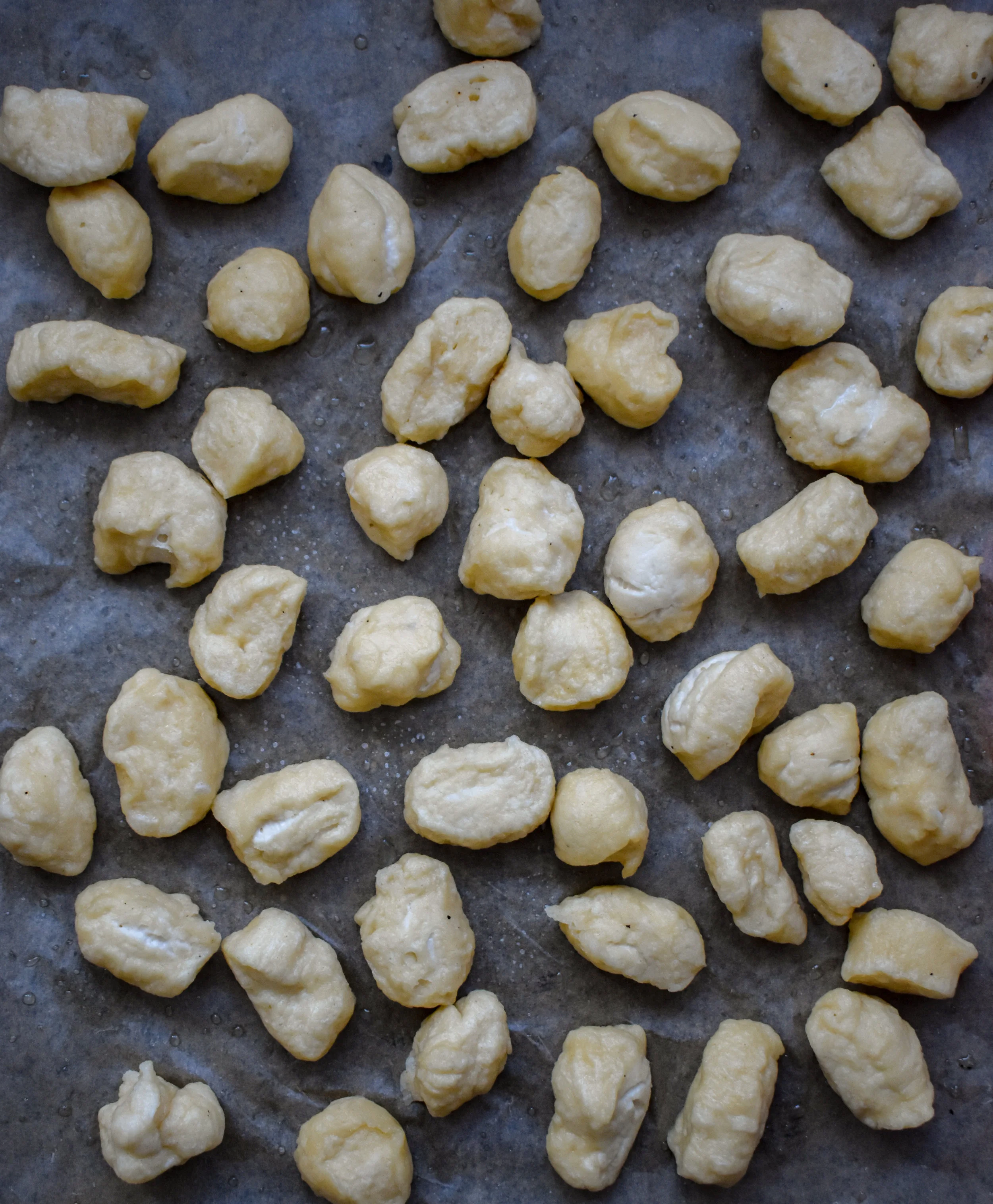 7. Once the dough is done rising, break into 6 smaller parts. Roll the dough in your hands and let it grow to about 12-16 inches as a long snake. Cut every 1 inch with a sharp knife and place on a parchment lined baking sheet.