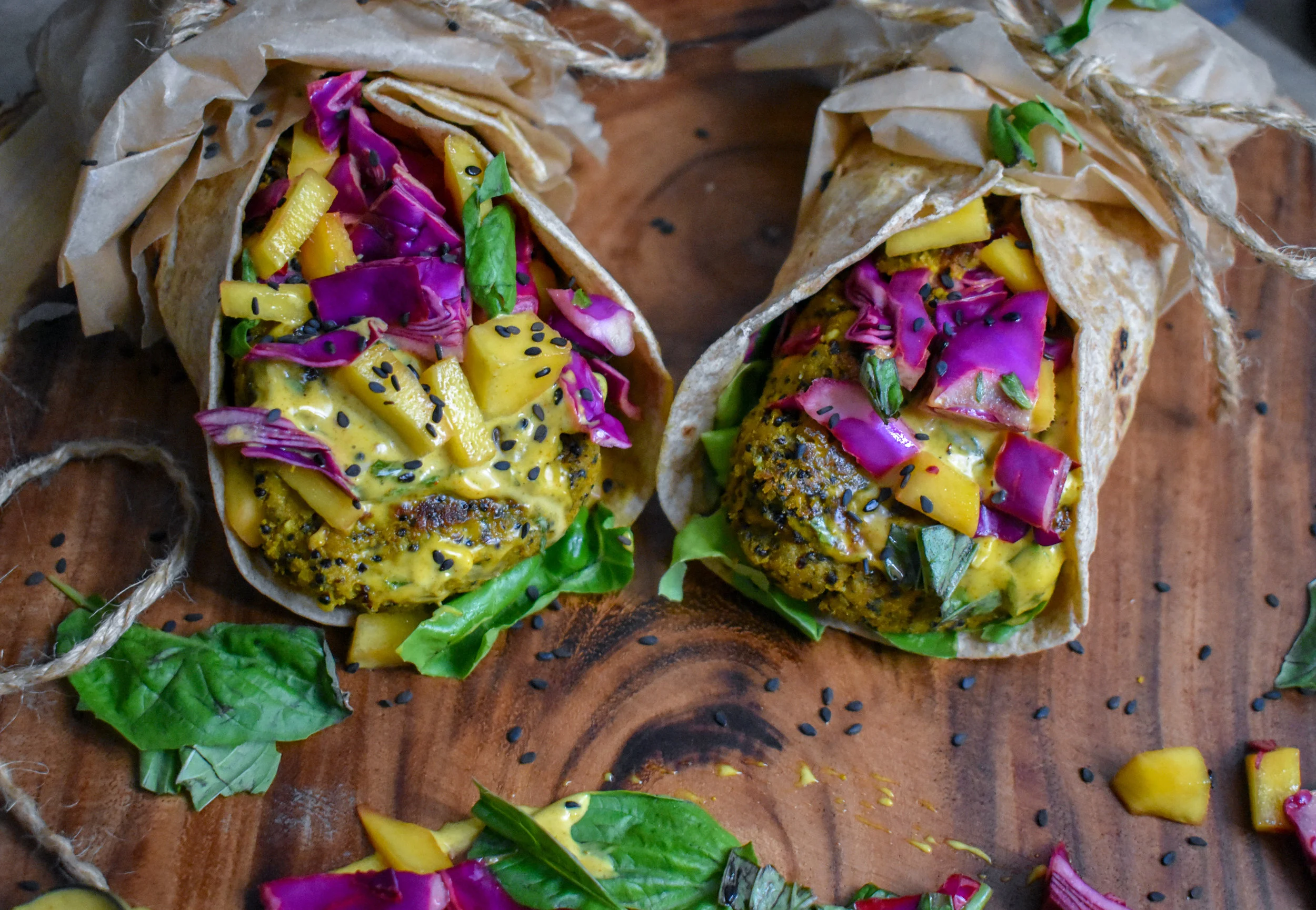 9. To serve, add one patty to roti on top of a handful of arugula, add 1-2 tbl of aioli, add 1/4-1/3 cup of the slaw, and add in fresh basil or sesame seeds for extra taste.
