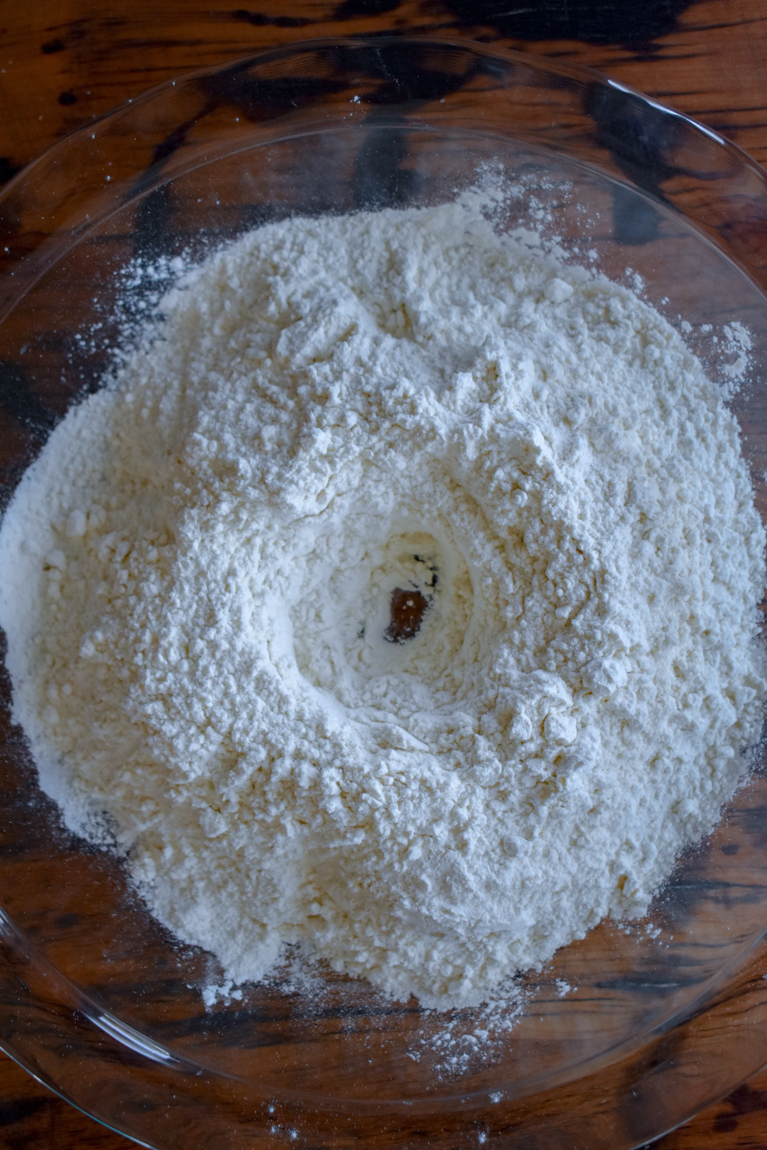 2. Next, in a shallow bowl (I use a pie pan) dump in your dry ingredients for the biscuits. Make a shallow dip in the middle that acts as a bowl to pour the milk in.