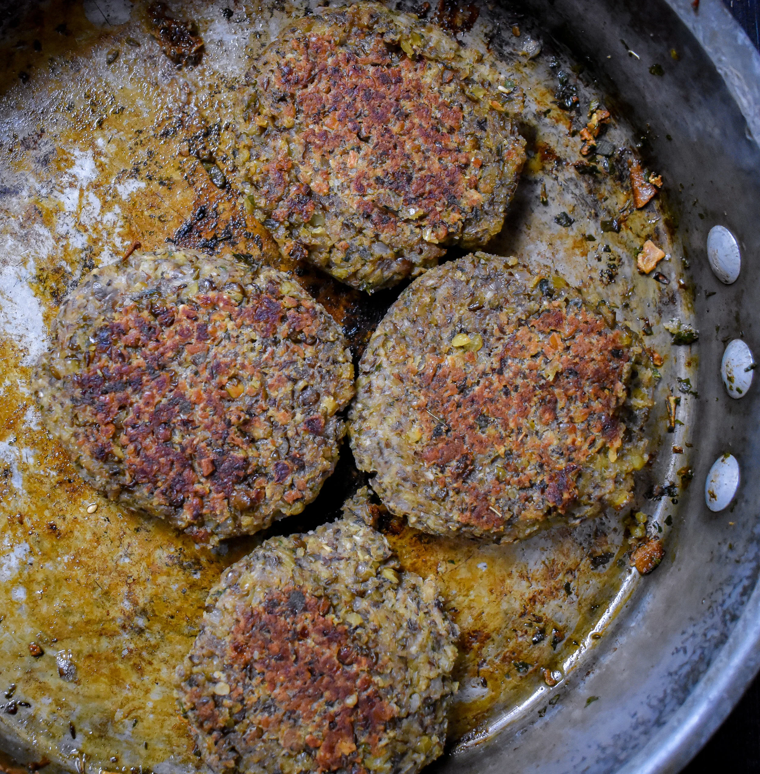4. Next, form the mixture into 4 large sausage patties with your hands. If its feels very sticky, add some oat flour, cornstarch, or other flour. You should have a bit of residue on your hands but the patty should not be sticking to your hand. Add the patties back to the large frying pan with 1 tbl of olive oil. Cook over medium heat for ~4 minutes on each side until browned.