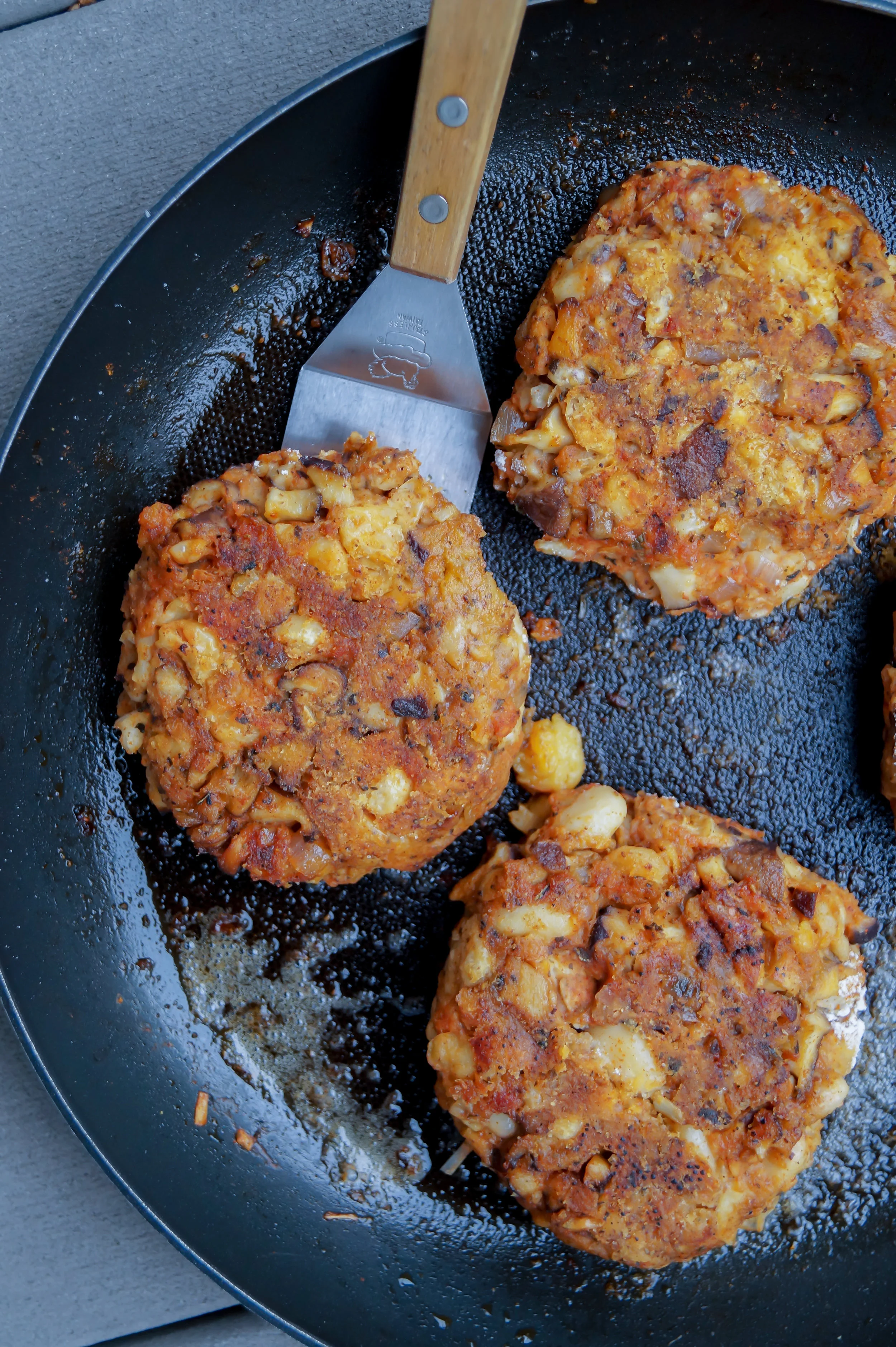 5. Using a large frying pan, add in 1.5 - 2 tbl of olive oil to coat the entire pan. Add to medium-high heat and warm for 60 seconds. Form the burger mixture into 4 large patties. Sprinkle a tiny amount of extra flour on top and rub it into the patty to help prevent sticking. Brown on each side for 4-5 minutes. Set aside.