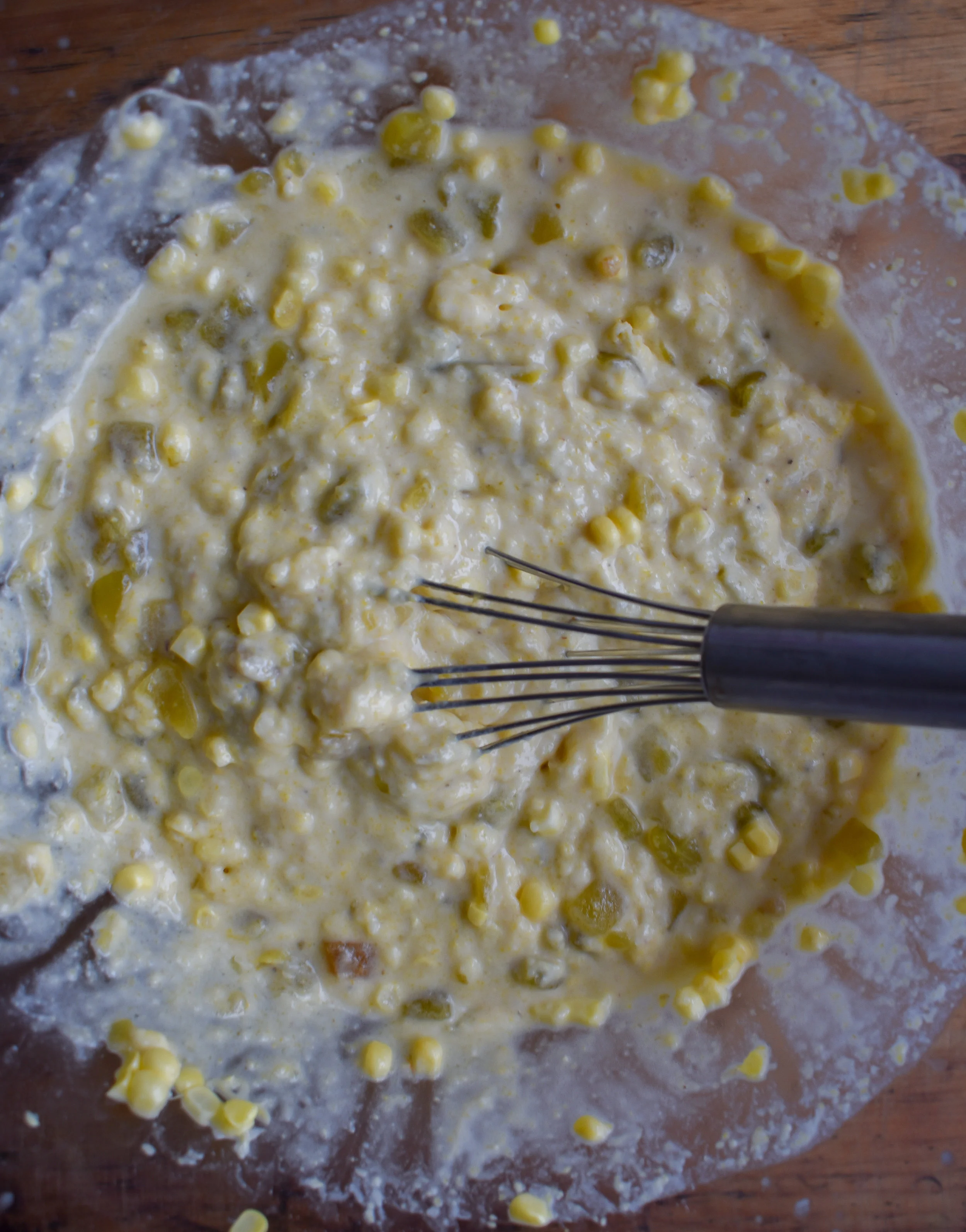 4. Next, make a well in the middle of the dry ingredients. Pour in milk, melted vegan butter, and applesauce. Whisk. While whisking, add in corn, chiles, and nutritional yeast.
