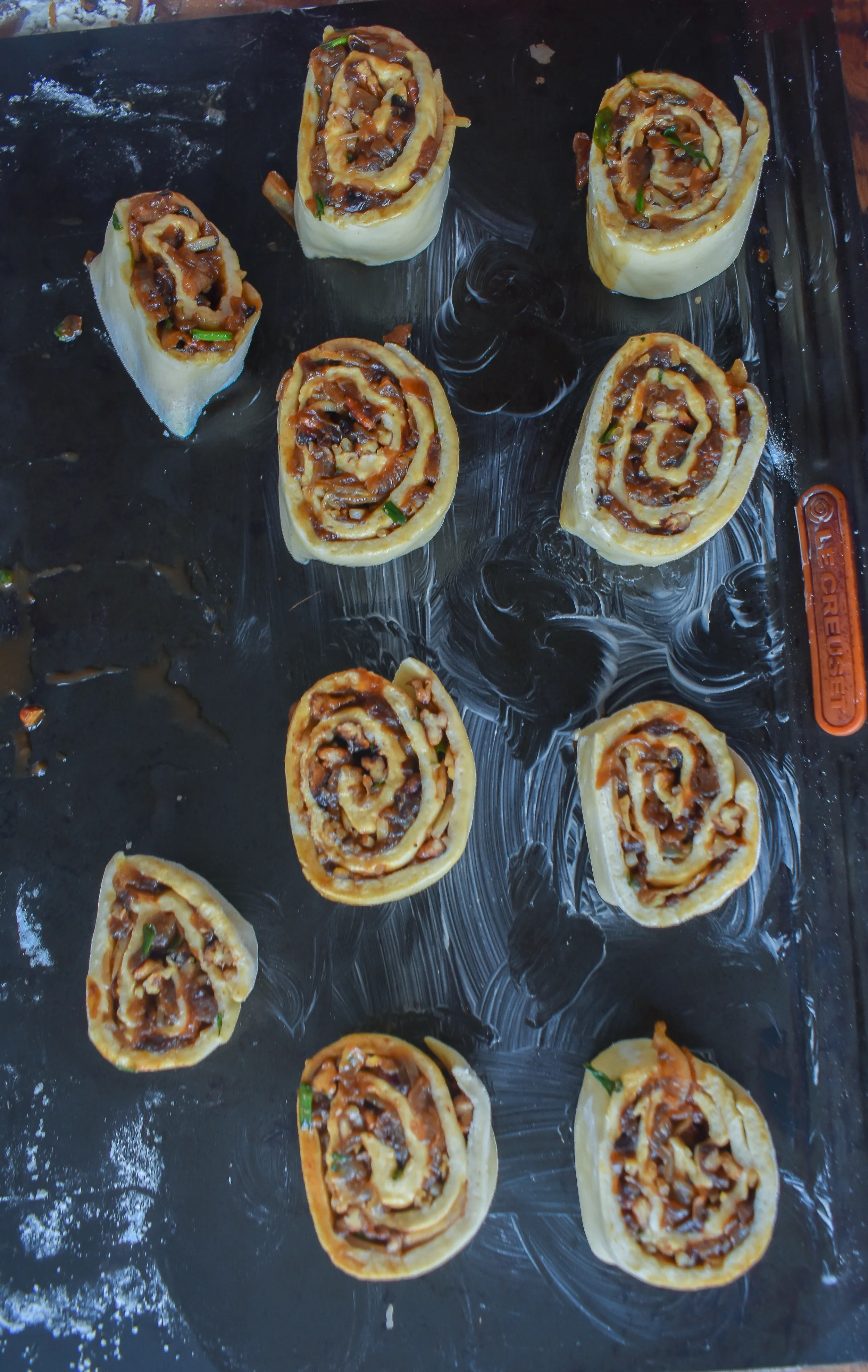 13. Place the rolls on a buttered/oiled baking sheet and add to oven at 375F. Bake for 10 minutes. Pull out and brush down with melted vegan butter with a pastry brush and add a sprinkle of cheese. Bake for another 10 minutes.