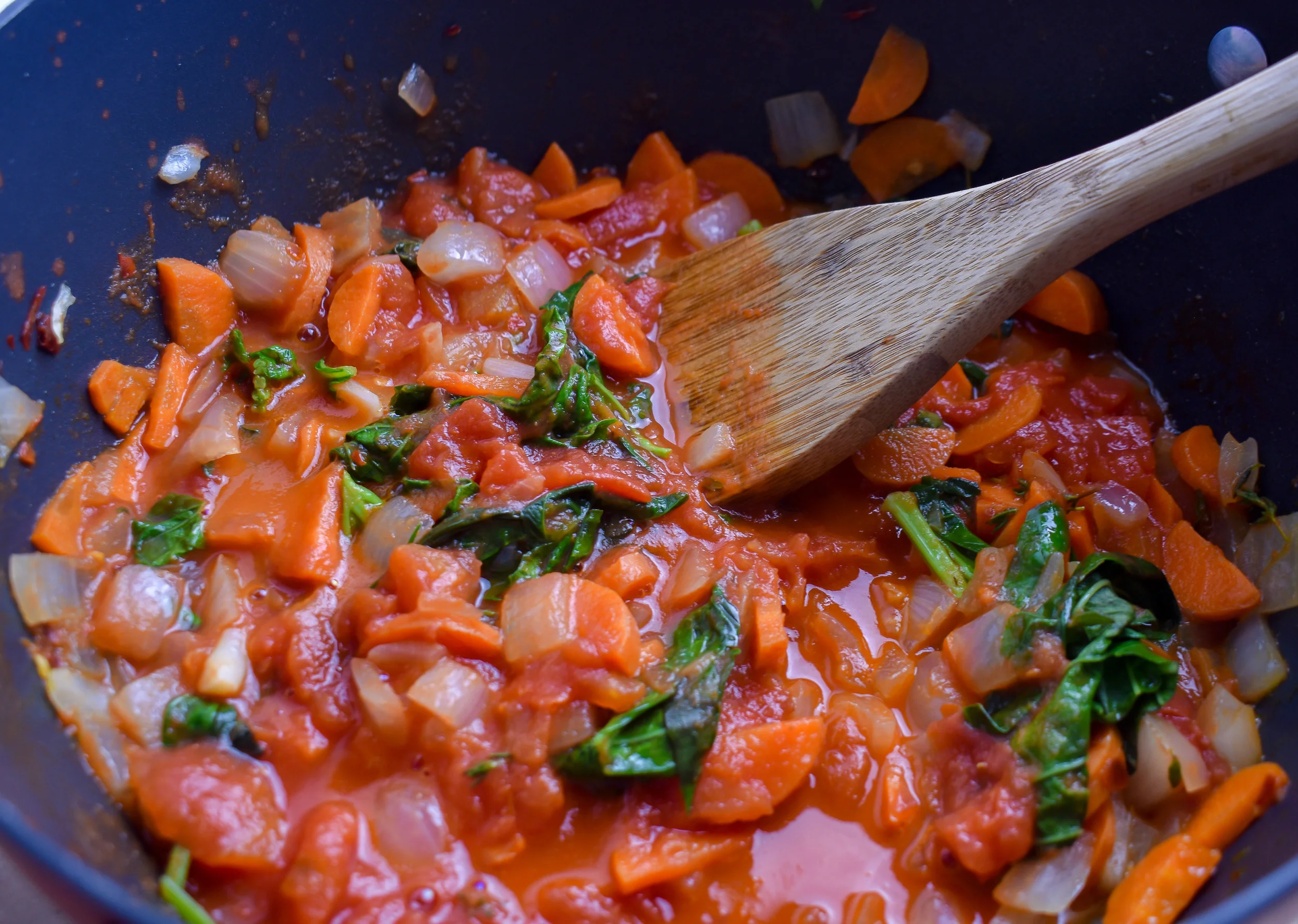 7. With 20 minutes left on the roast, add onions/butter/wine/carrots from soup ingredients to a large stock pot / soup pot. Cook over medium-high heat for 15 minutes. Next, add the fresh basil, canned tomatoes, salt, pepper, and thyme. Cook for 4-5 minutes then add in the tomatoes from the oven. Use a wooden spoon to break them down and simmer on medium low heat until the grilled cheese is done.