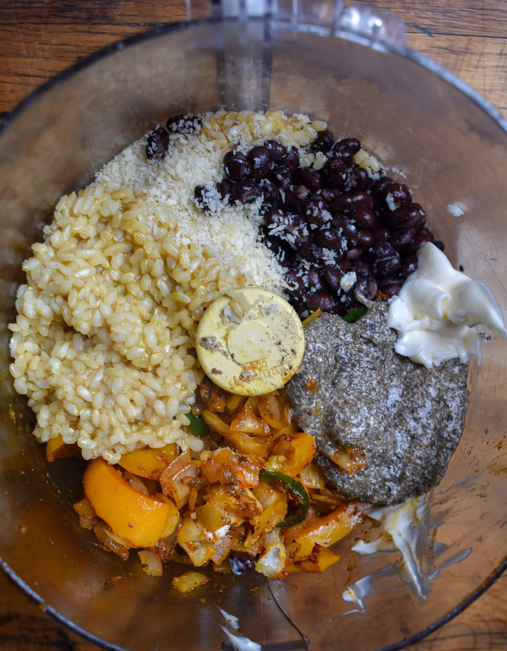 6. Once the rice is done, add the rice, black beans (reserve 1/2 cup from the cans), breadcrumbs, pepper/onion mixture, mayo, flax egg, and all other patty ingredients to a food processor (you can also mix in a bowl by hand or with spoon). Pulse 10-12 times to mix. I like to leave it chunky. Pour in reserved 1/2 cup of black beans and mix in with a spoon.