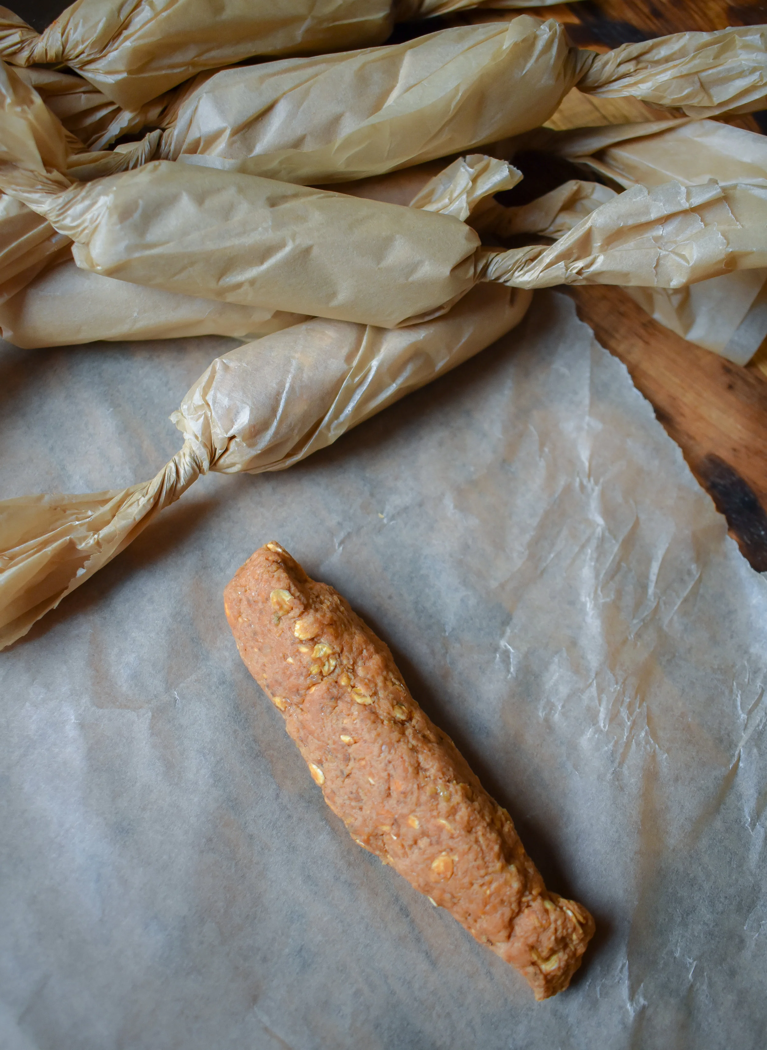 6. After well kneaded, divide the mixture into 6-8 dogs. Place on a square of parchment paper, roll like a candy and tighten at the ends.