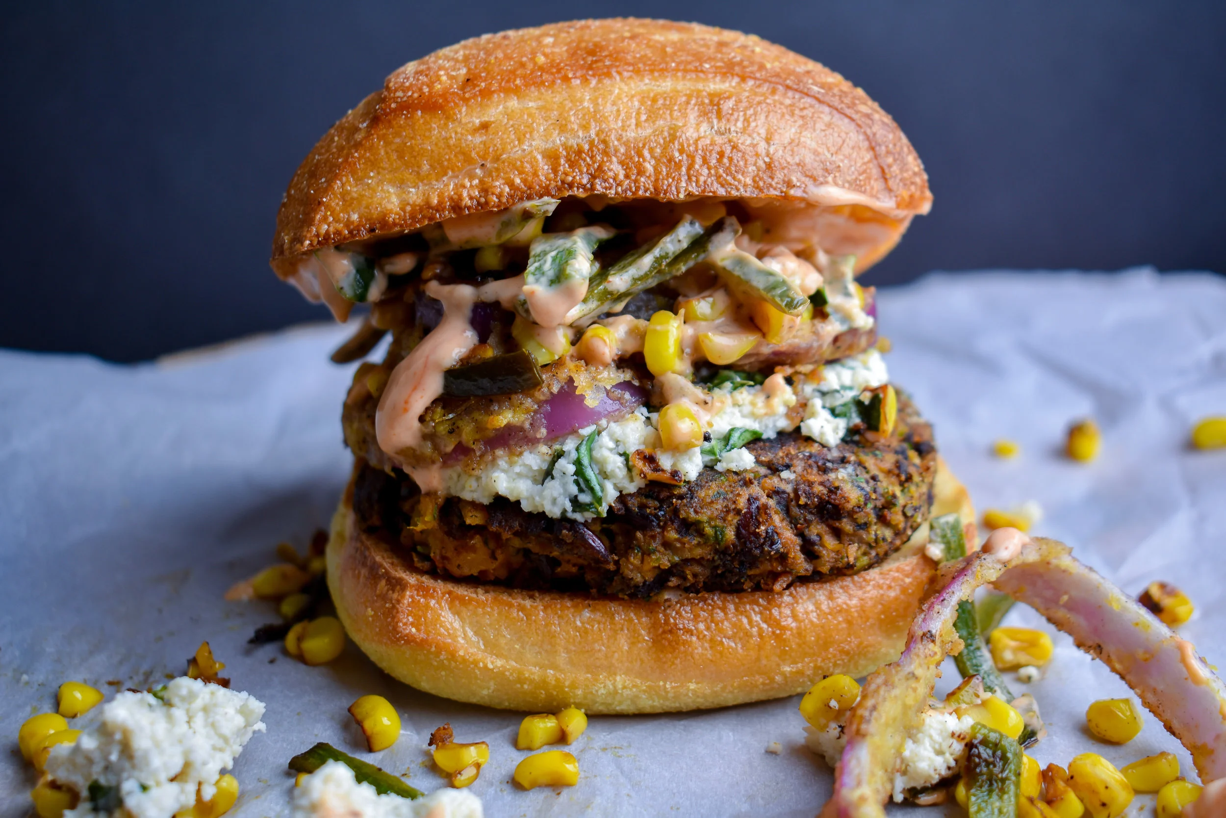 5. To finish, after the onions, add more 2 tbl oil/butter to the pan. Reduce heat to medium and add patties. Cook 3—4 minutes on each side until browned. To form. Add patty, 1/4 the goat cheese, red onions, the corn poblano hash, and then a nice layer of the aioli to a bun.