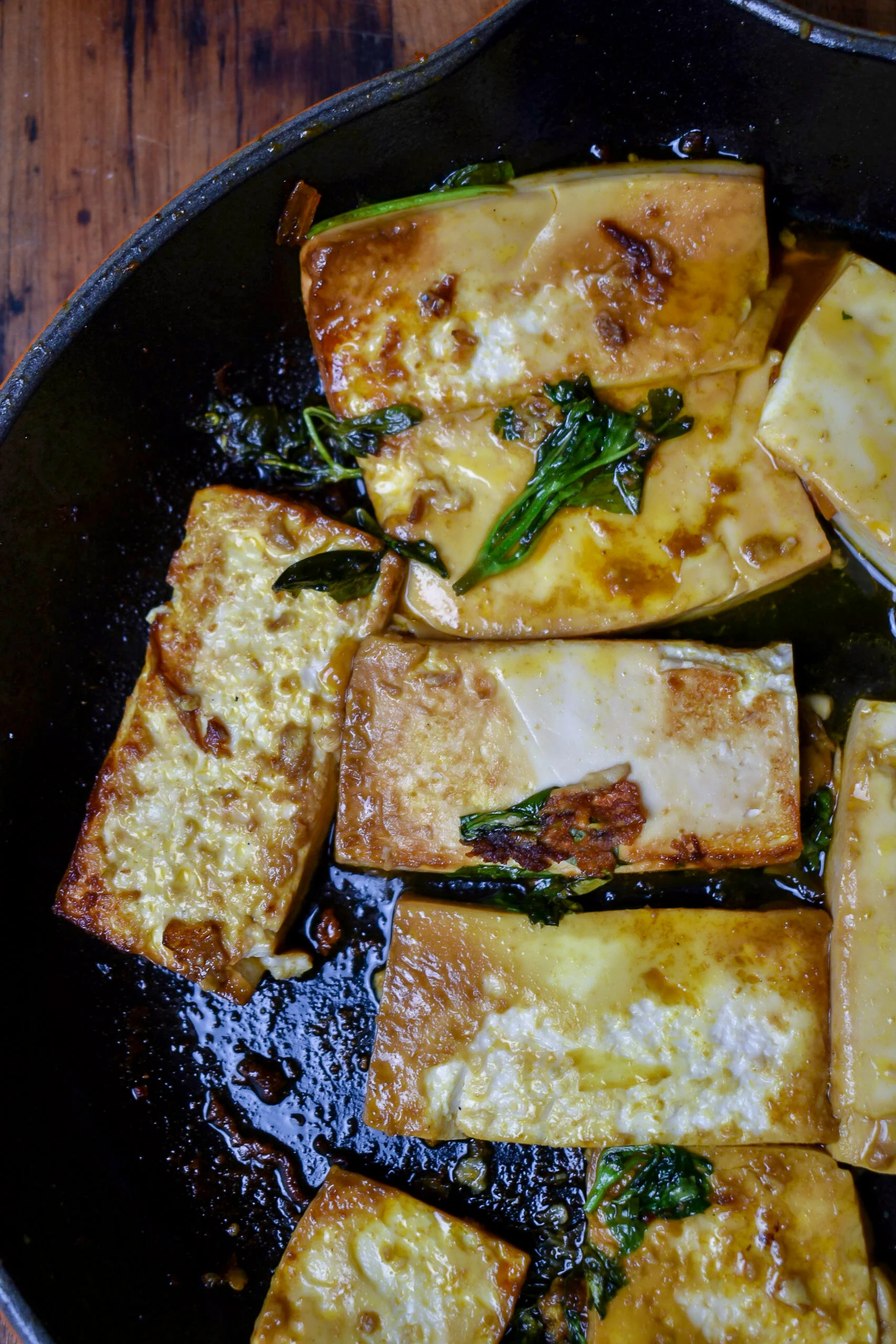 3. To the same pan, add sesame oil. Heat for 60 seconds over medium heat then add in tofu + liquid aminos. Sear on one side for 4 minutes then add in rest of ingredients and sear on other side 4 minutes then flip back for another 1-2. Add more time until both sides are browned and crispy on edges but soft in the middle.