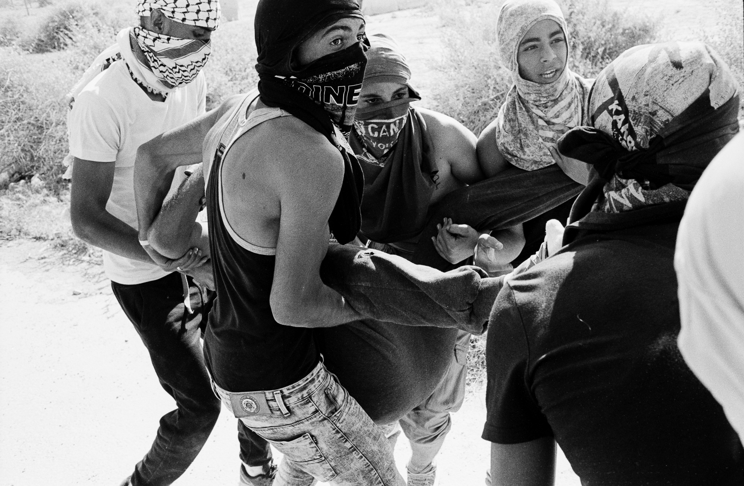 Young men Carry the wounded to the waiting ambulance during clashes with the IDF, in Jericho. 
