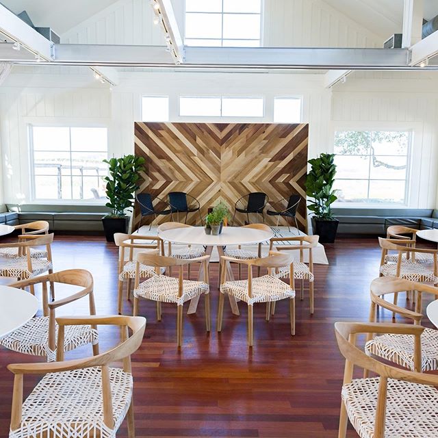 Corporate set @carnerosresort. Loving our natural wood backdrop, with our Chase lounge chairs and Faded Stripe rug on the stage. 48&rdquo; Nantucket tables with minimal florals and our contemporary Bea chairs complete the look. Design, Decor, Floral,