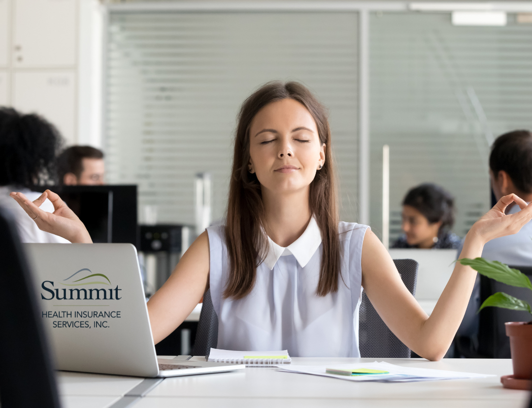 woman at desk in meditation pose