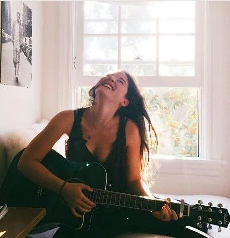 WomanGuitarLaughingRoom.jpg