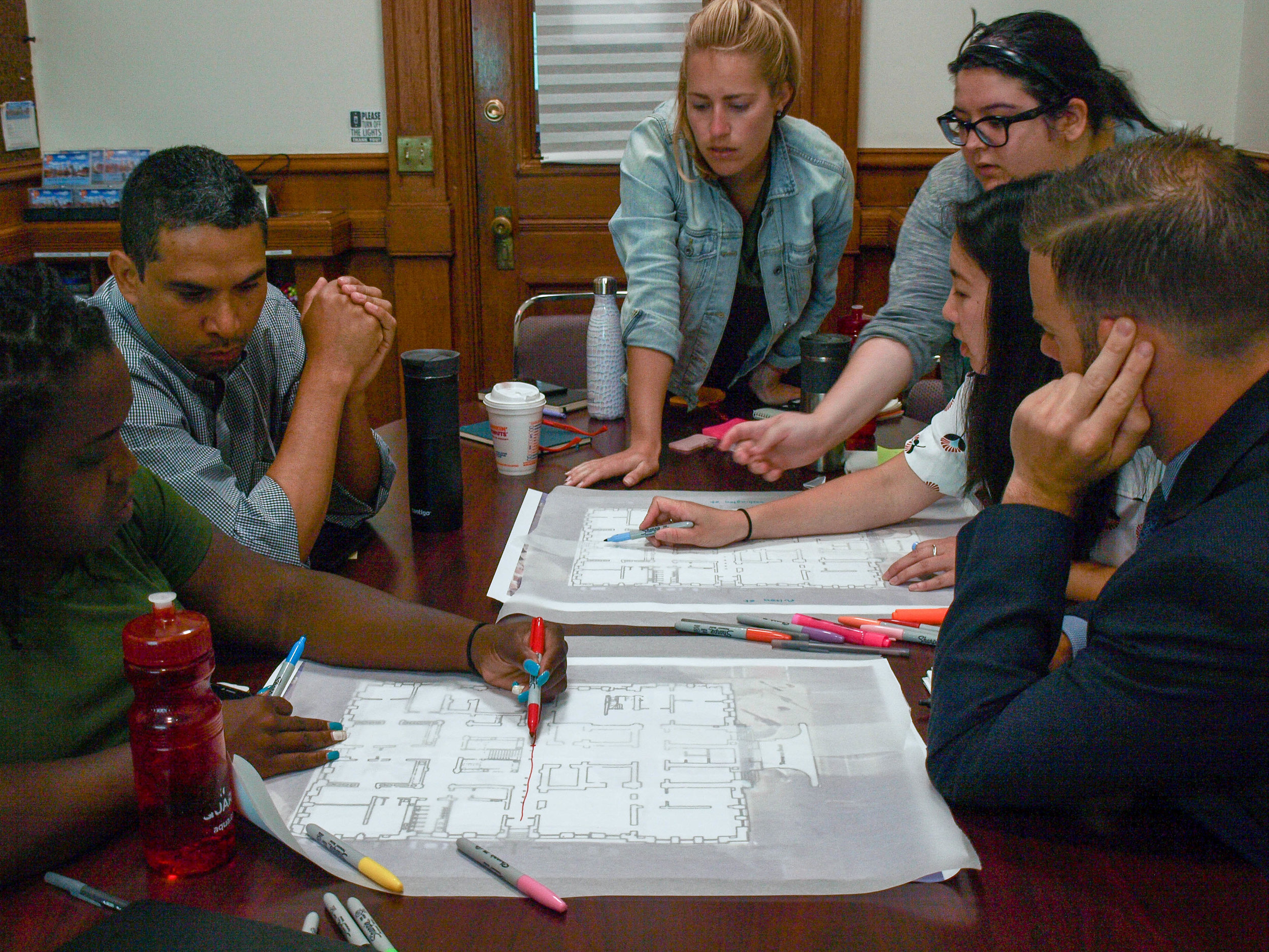 two groups working through the entry sequence of city hall during the design thinking workshop
