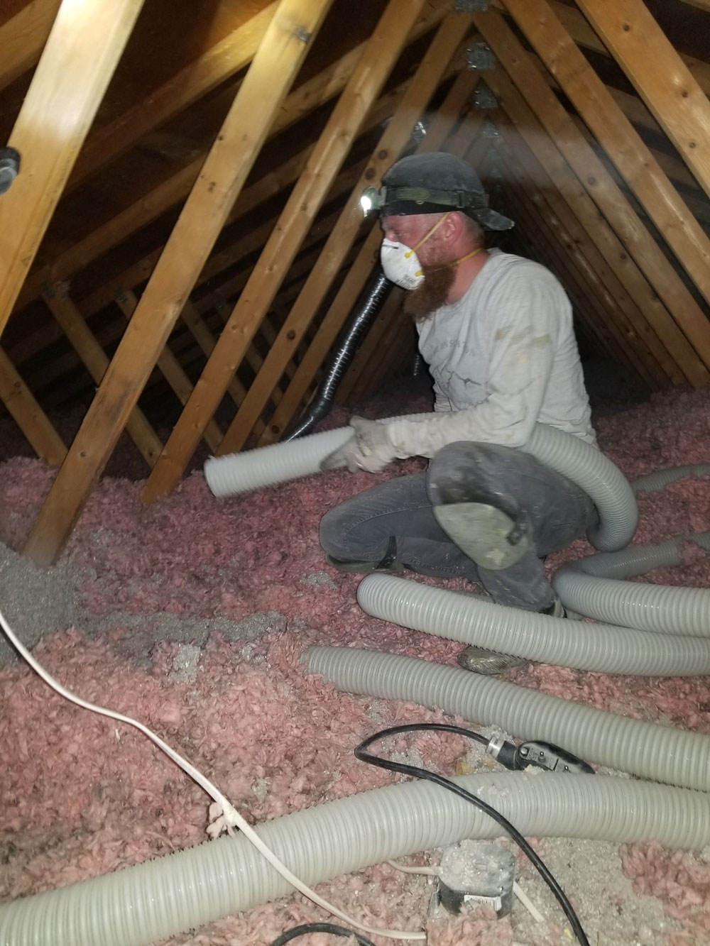 man-adding-insulation-with-a-large-tube-in-an-attic.jpg
