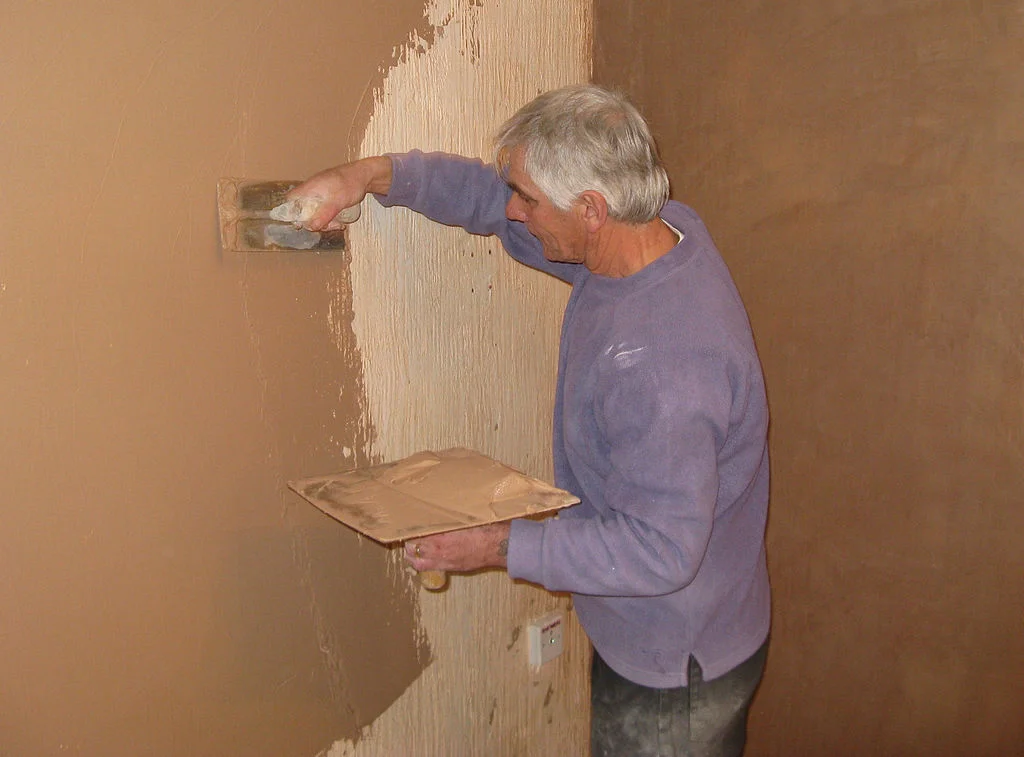 1024px-Plasterer_at_work_on_a_wall_arp.jpg