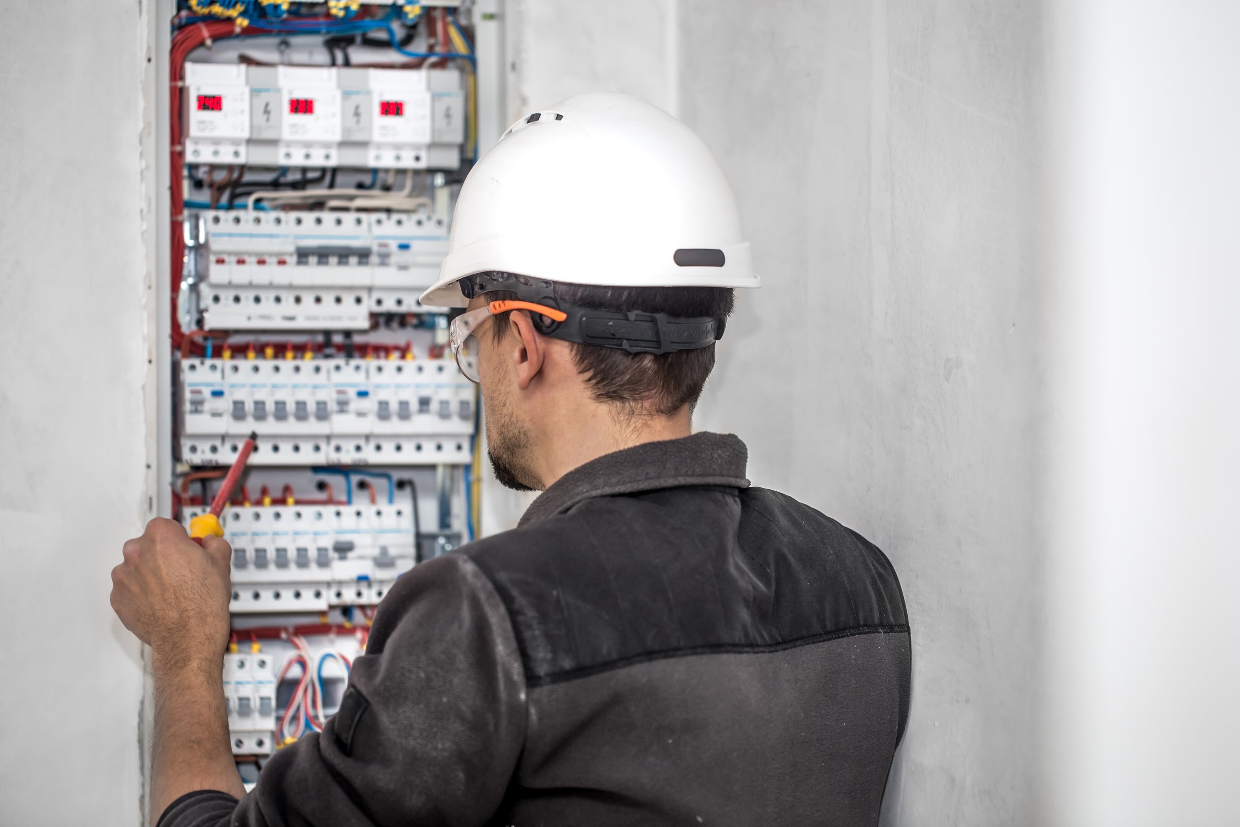 man-electrical-technician-working-switchboard-with-fuses-installation-connection-electrical-equipment.jpg