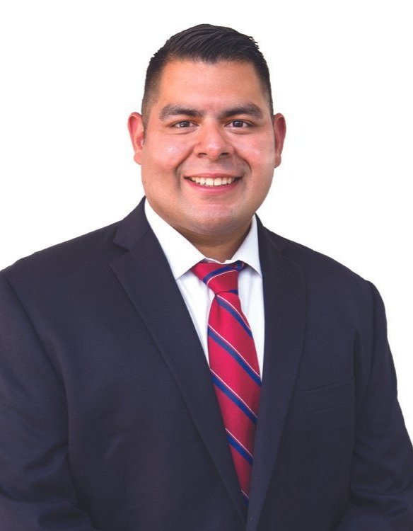 Portrait of a smiling man in a business suit and red-striped tie against a white background.