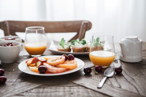 Plate of fruit and healthy muffins with fruit juice for breakfast