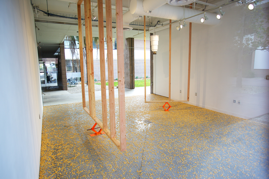  Flexible Necks, 2015 Dimensions variable 2 x 4s, jacks, corn, time release corn feeder  Installation view: "Flexible Necks" at UCSB Glassbox Gallery, Santa Barbara CA 