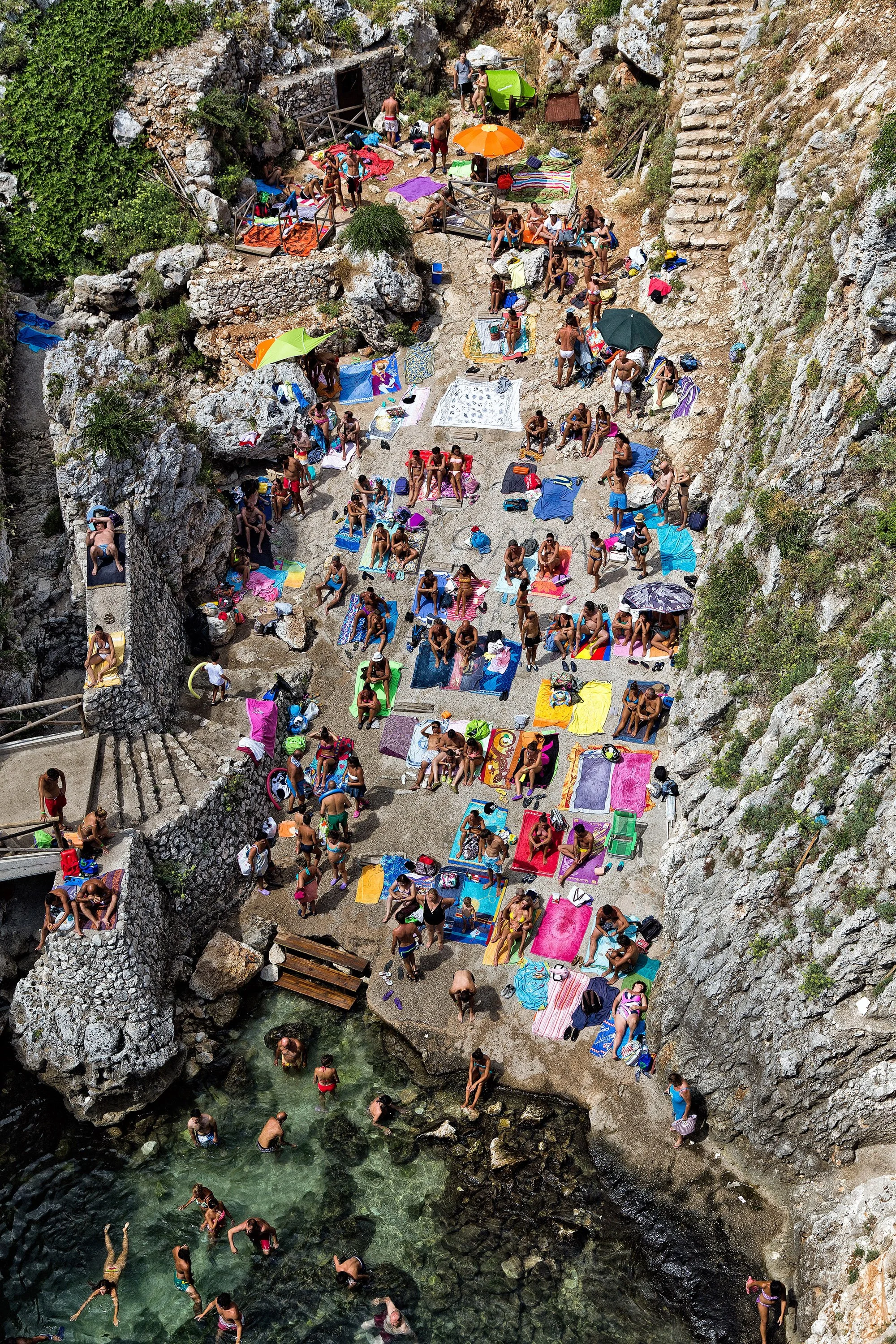  This project explores coastal landscapes shaped by human presence. Shot in rocky seaside locations, the images depict bodies resting, standing, or gathering on uneven terrain, treated as part of the landscape rather than its subject.The photographs 
